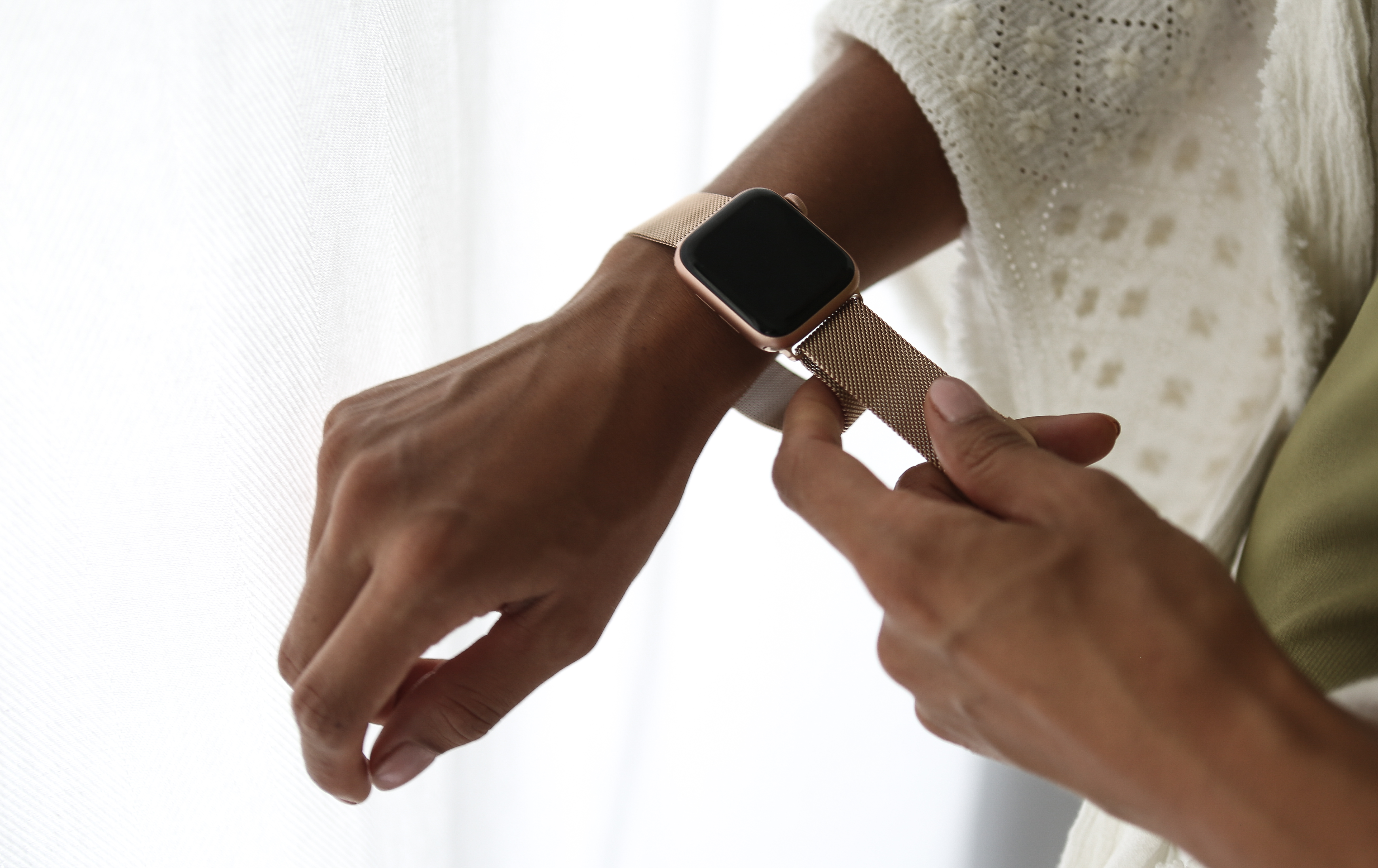 Hand mit goldener Uhr. Weißer Hintergrund.