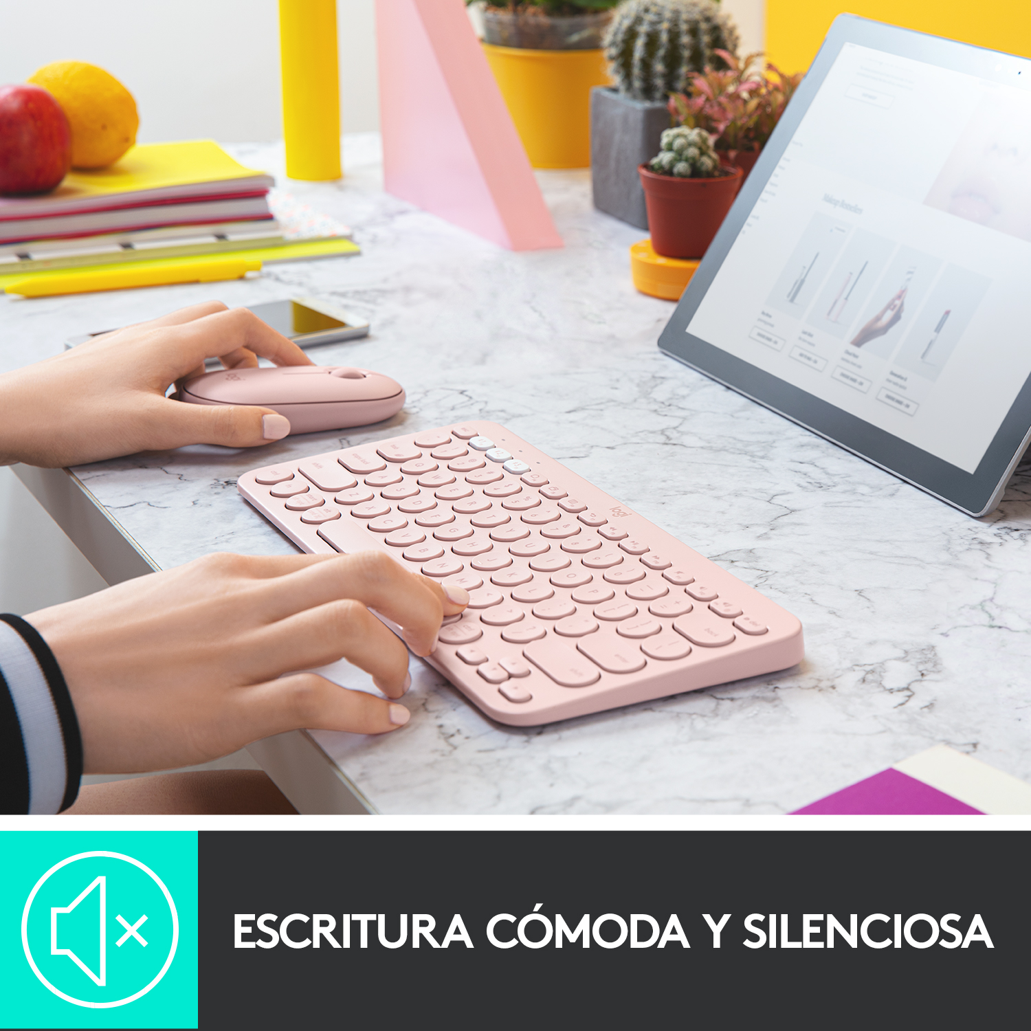 Una persona usa un teclado y ratón inalámbricos rosas en un escritorio de mármol.