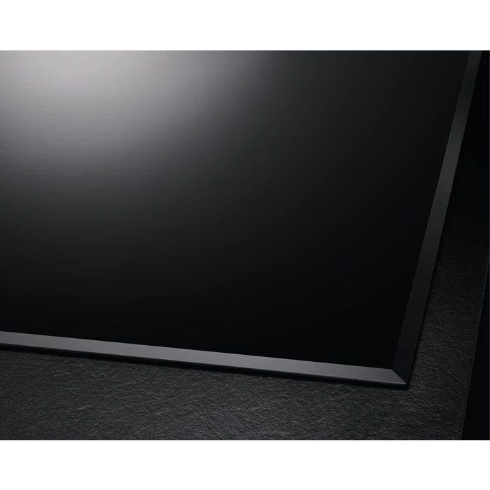 Un panel de encimera negro. La superficie es brillante y reflectante.