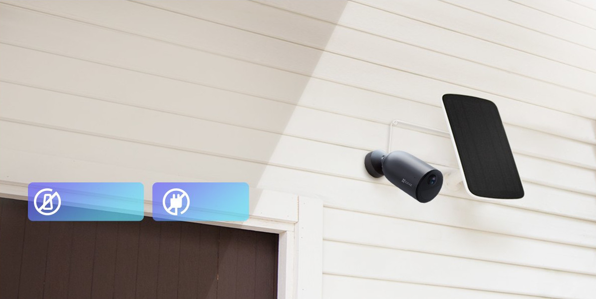 Security camera mounted on a white wall with solar panel.