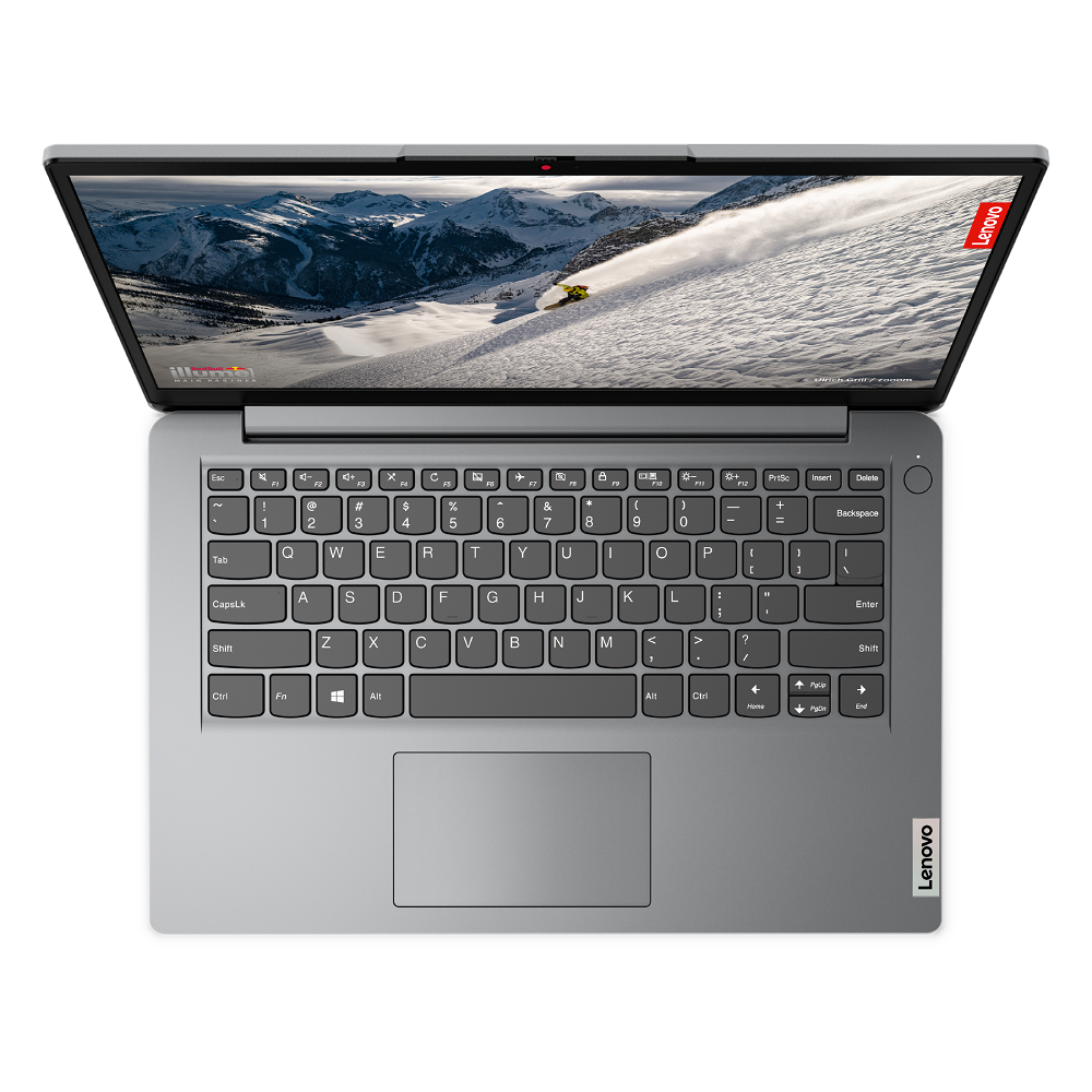 Ordenador portátil abierto sobre una superficie negra, la pantalla muestra una escena de montaña nevada. Logotipo Lenovo visible.