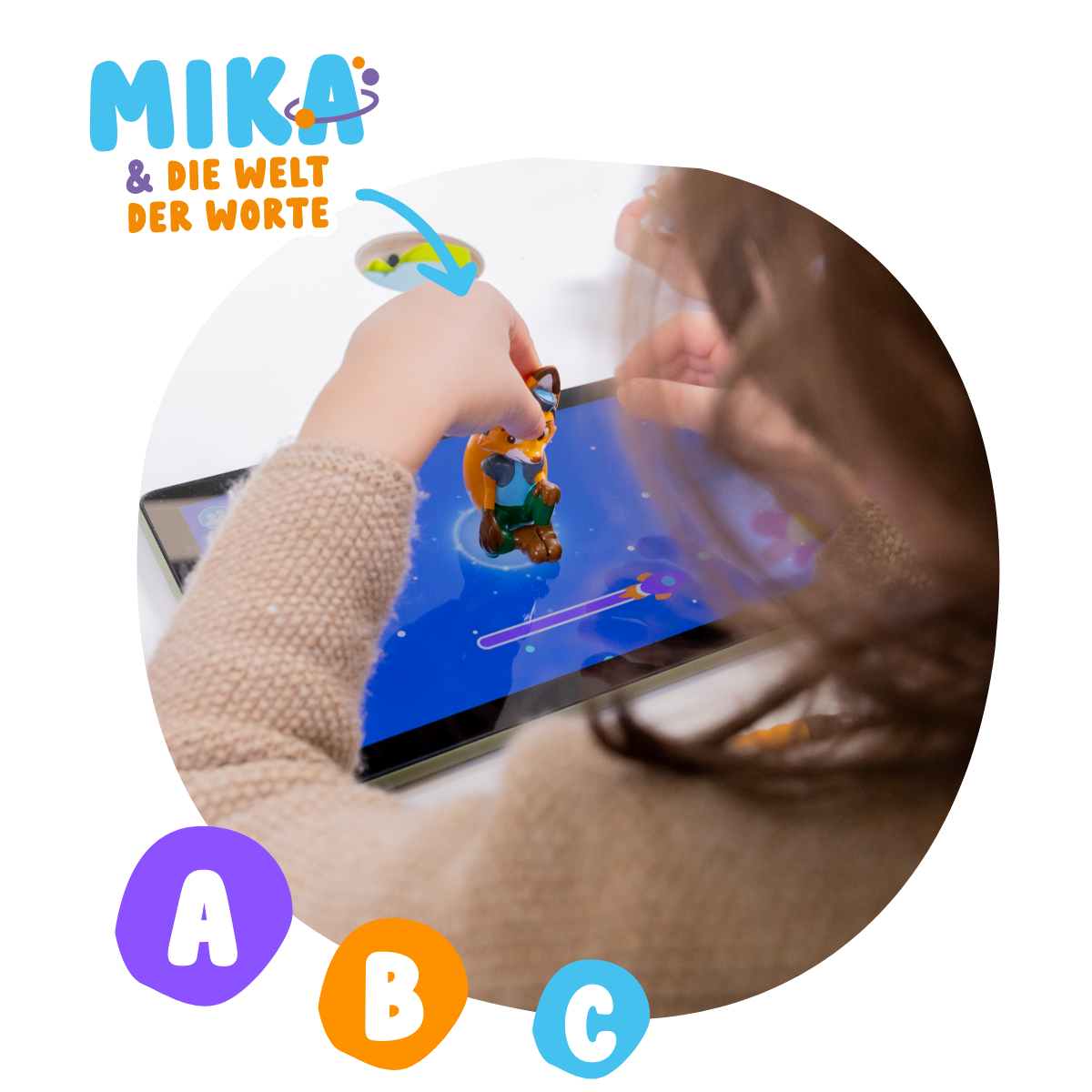 Ein Kind spielt mit einem Spielzeugfuchs auf einem Tablet. Das Tablet hat ein Spiel mit A,B,C.