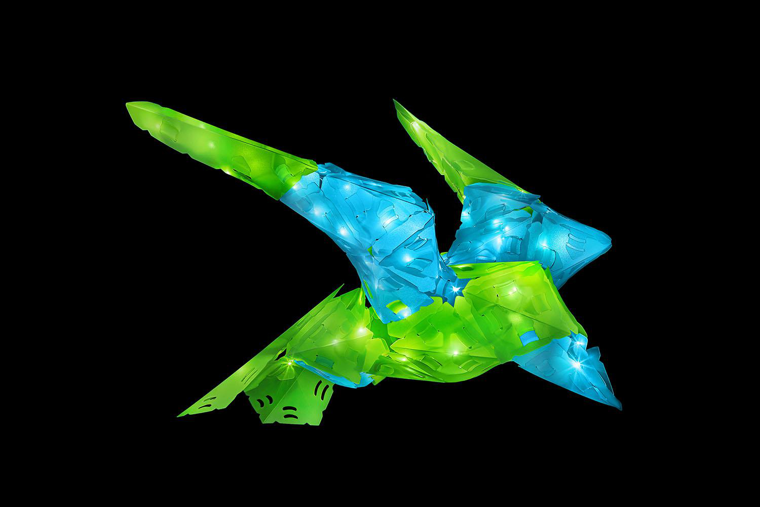 Abstrakter Dinosaurier aus grün und blau leuchtenden Formen auf schwarzem Hintergrund.