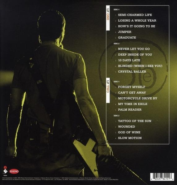 Rückseite einer Vinyl-Schallplatte mit Songtiteln. Mann spielt Gitarre. Dunkler Hintergrund.