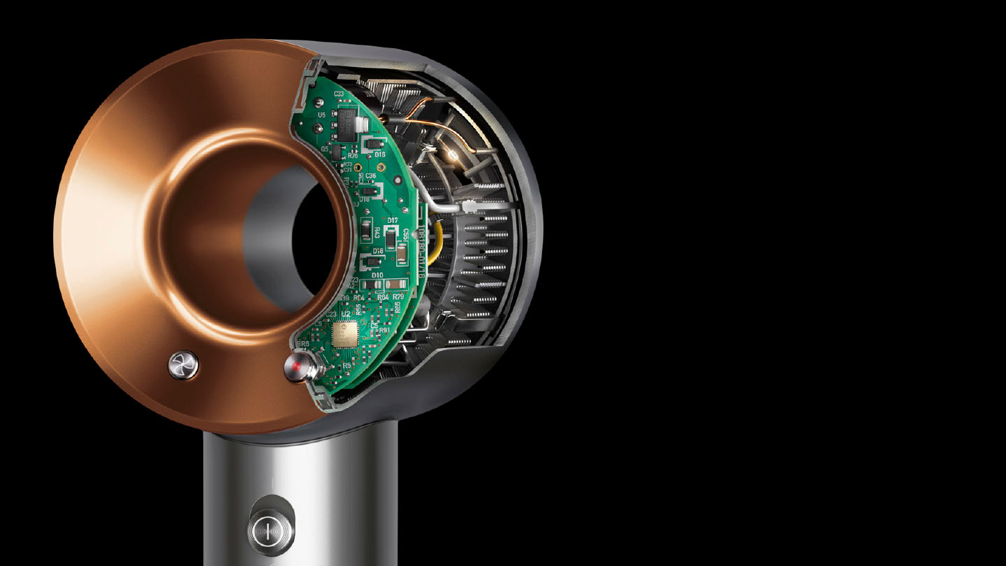 Dyson föhn doorsnede met interne componenten, koperen ring en groen circuitbord.