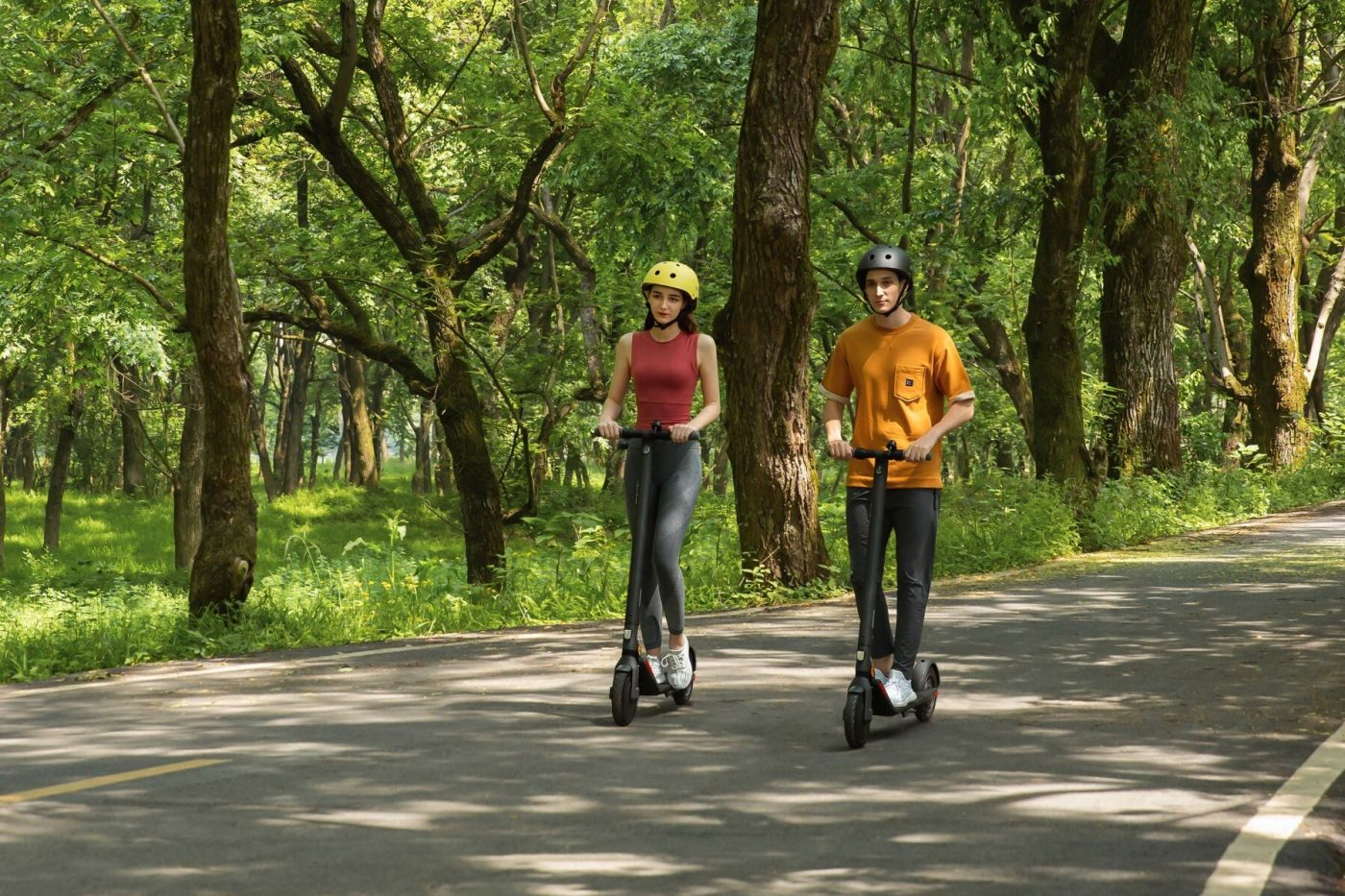 İki kişi, ağaçlı bir parkta asfalt bir yolda elektrikli scooter ile gidiyor.