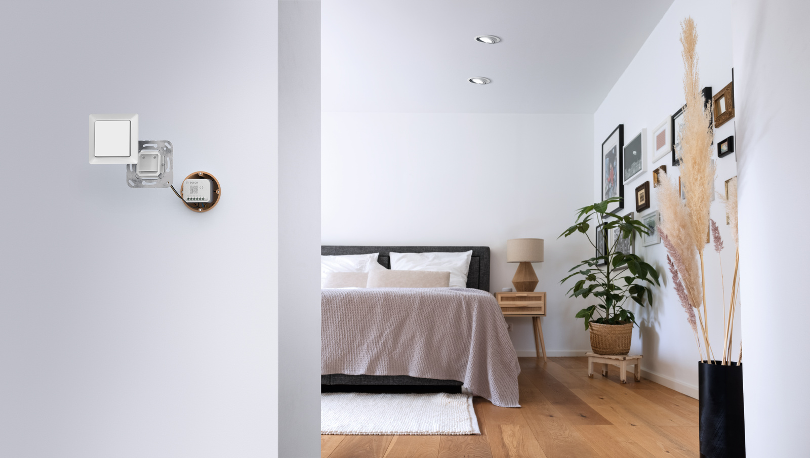 Schlafzimmer-Interieur mit Bett, Licht und Kunst. Zwei Lichter an der Decke, weiße Wände.