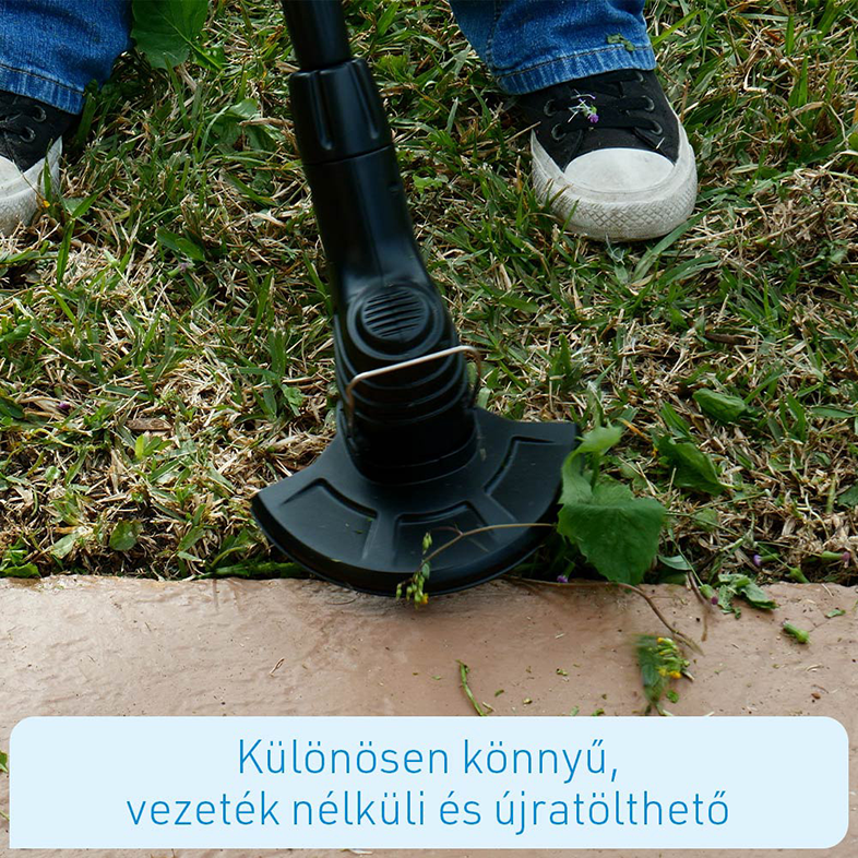 Egy személy fekete-ezüst szegélynyíróval nyírja a füvet.
