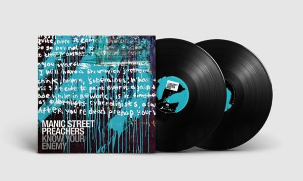 Zwei schwarze Schallplatten und Albumcover mit einem Wandgemälde mit Schrift.
