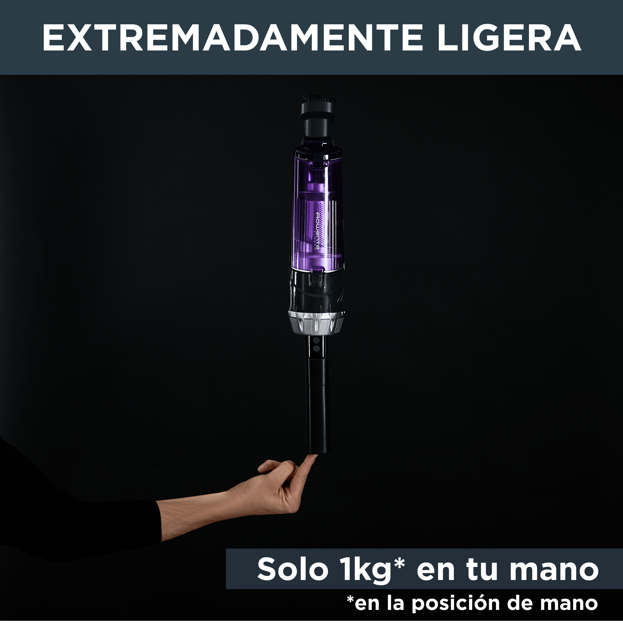 Una mano sostiene una aspiradora morada y plateada, contra un fondo negro.