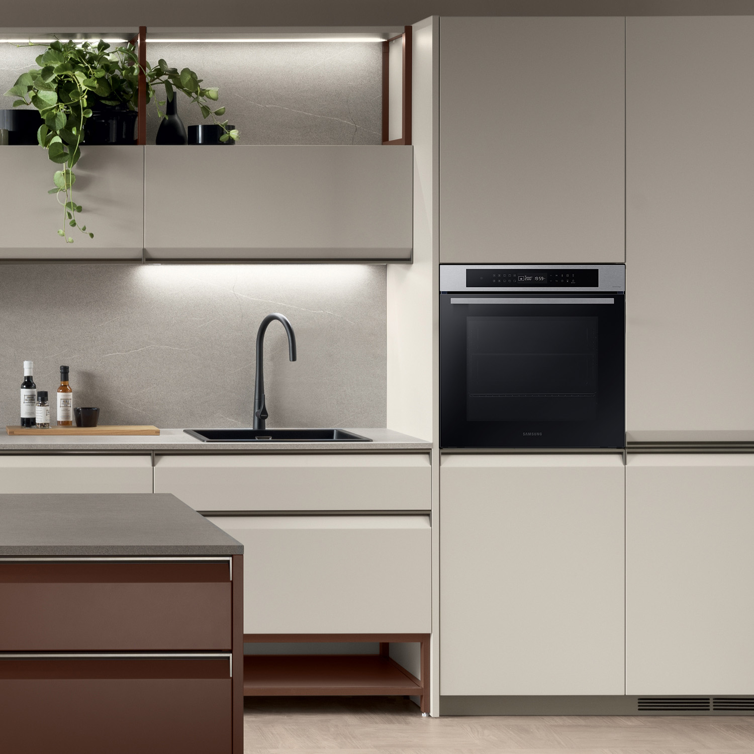 Cucina moderna con forno a incasso e lavello nero; piante e decorazioni.