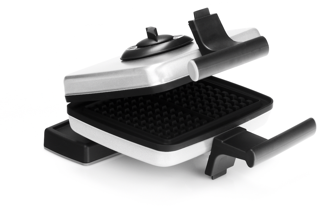 Open waffle iron in grayscale, white surface with black waffle area.