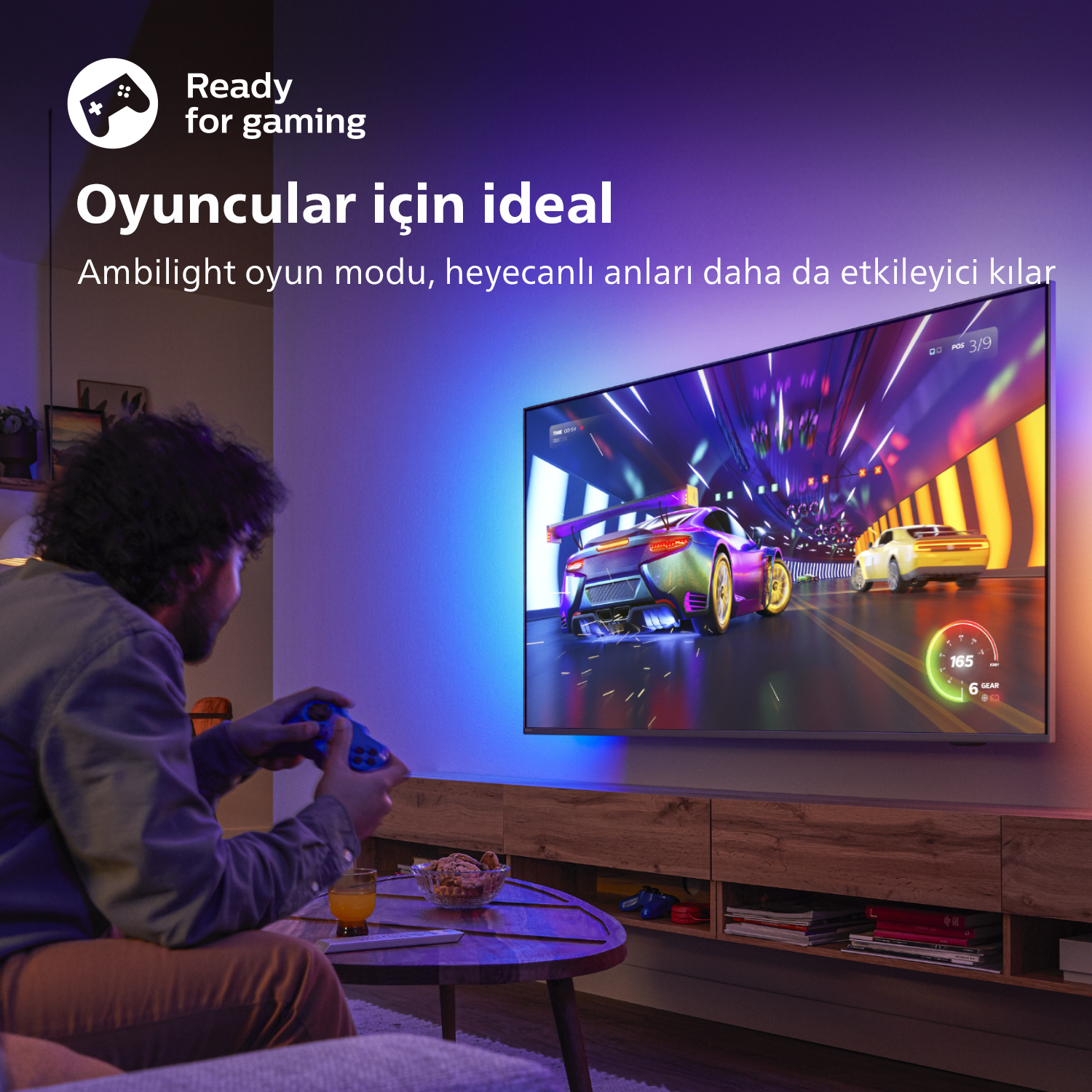 Renkli aydınlatmalı büyük bir TV'de video oyunu oynayan bir kişi.