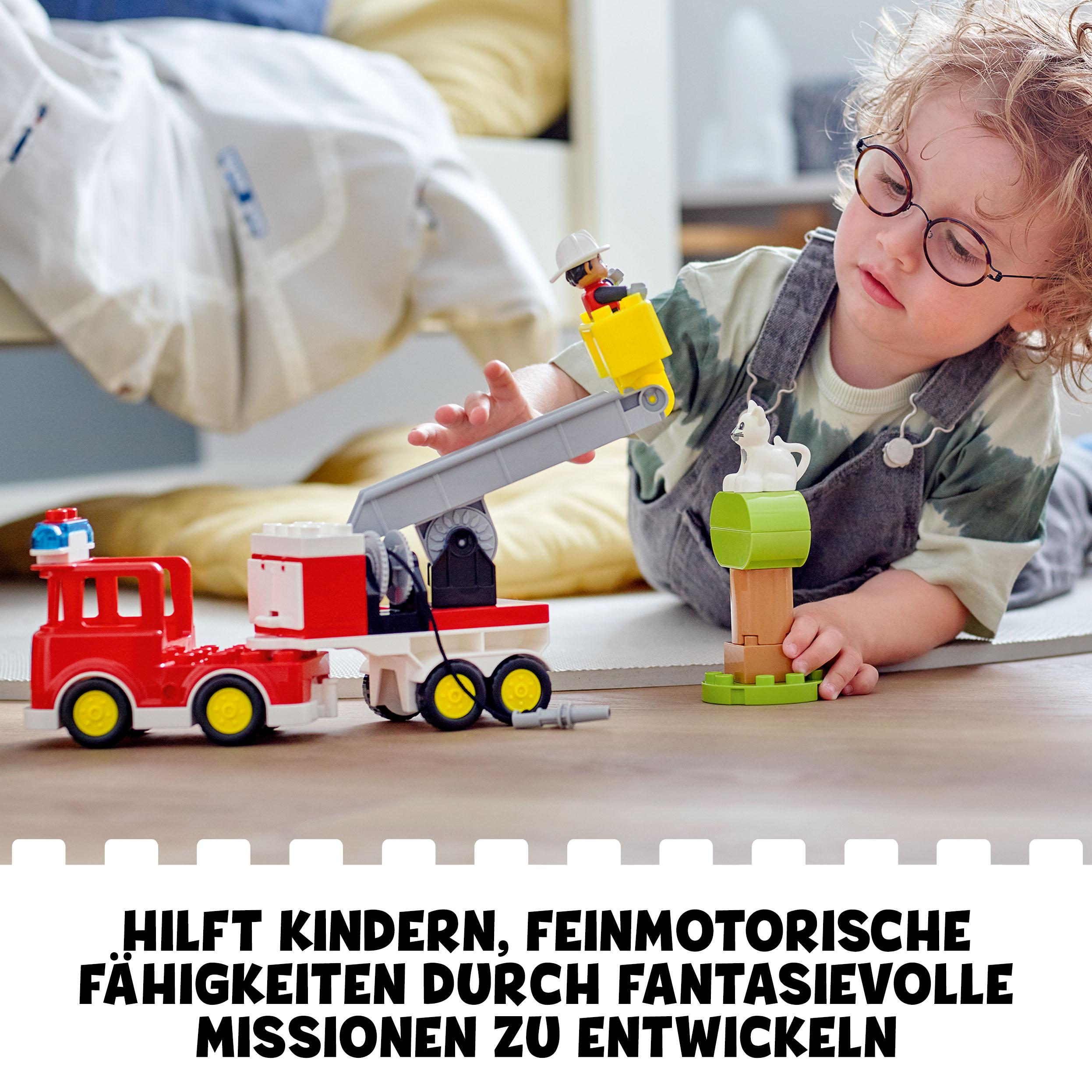 Kind spielt mit Feuerwehrauto und Kran, Text: "Hilft Kindern, feinmotorische Fähigkeiten zu entwickeln..."