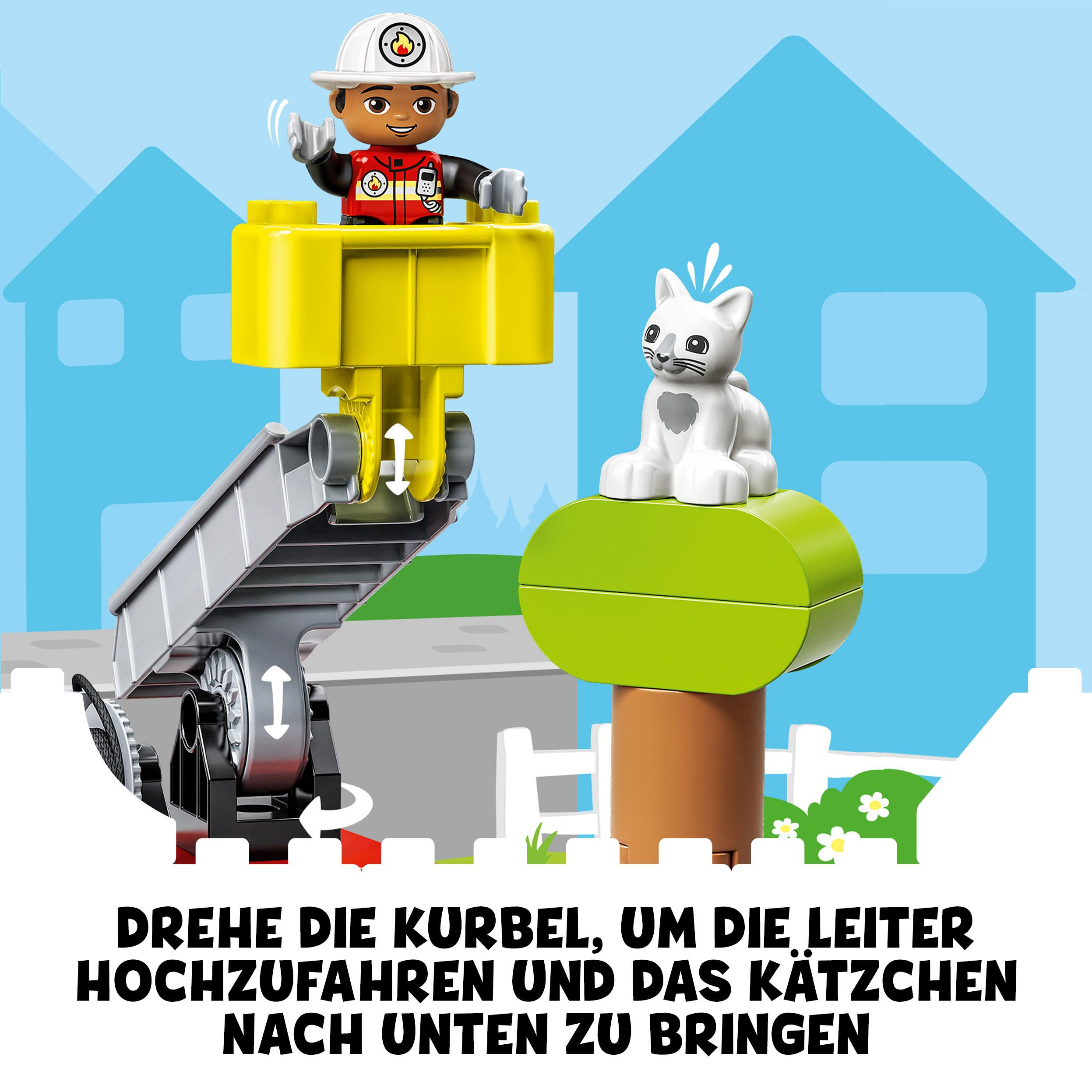 Lego Duplo Set: Ein Feuerwehrmann hebt eine Katze in einem gelben Aufzug hoch. Ein einfaches Haus und Baum im Hintergrund.