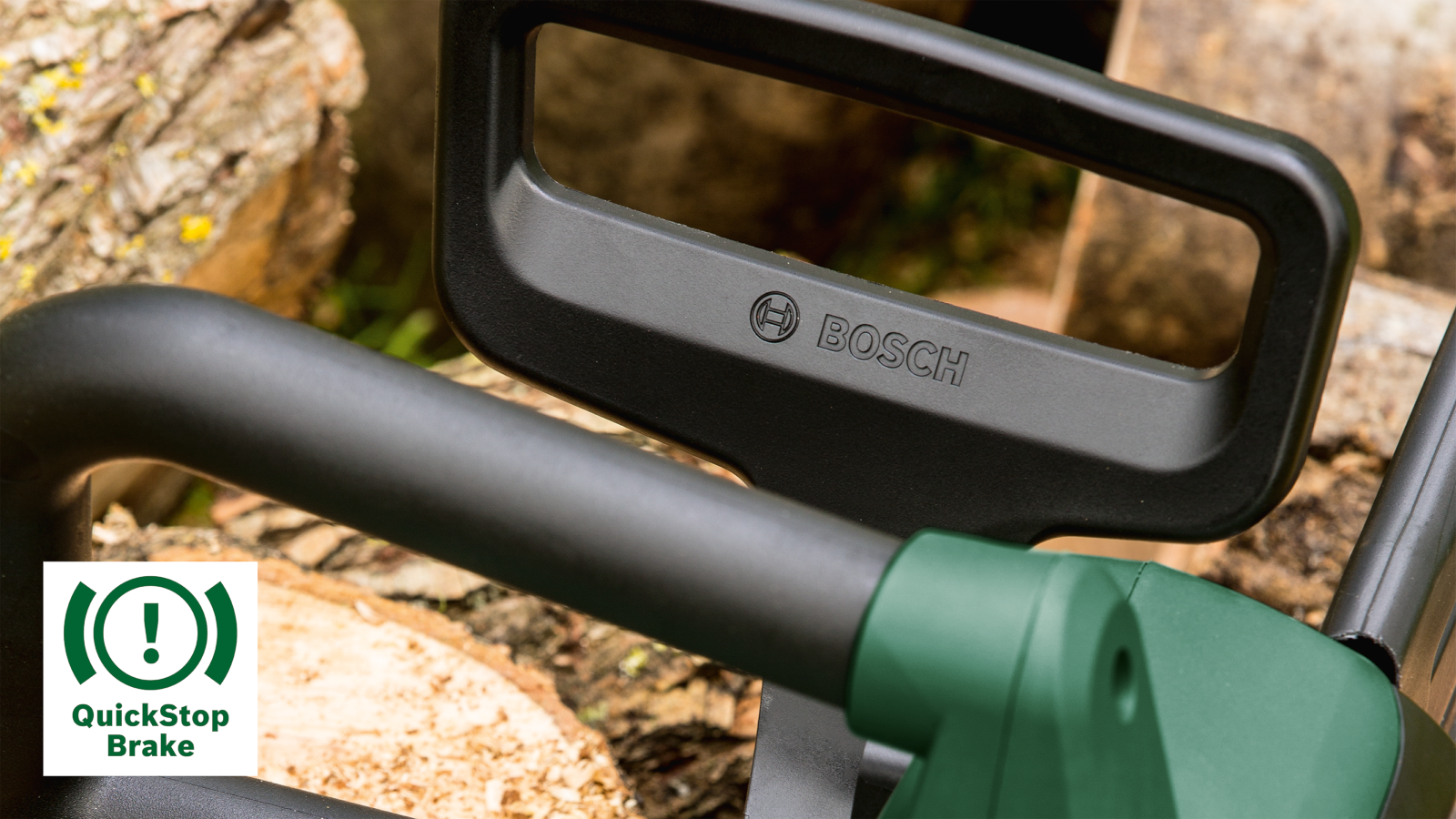 Fekete és zöld láncfűrész fogantyú Bosch logóval, QuickStop Brake címkével.