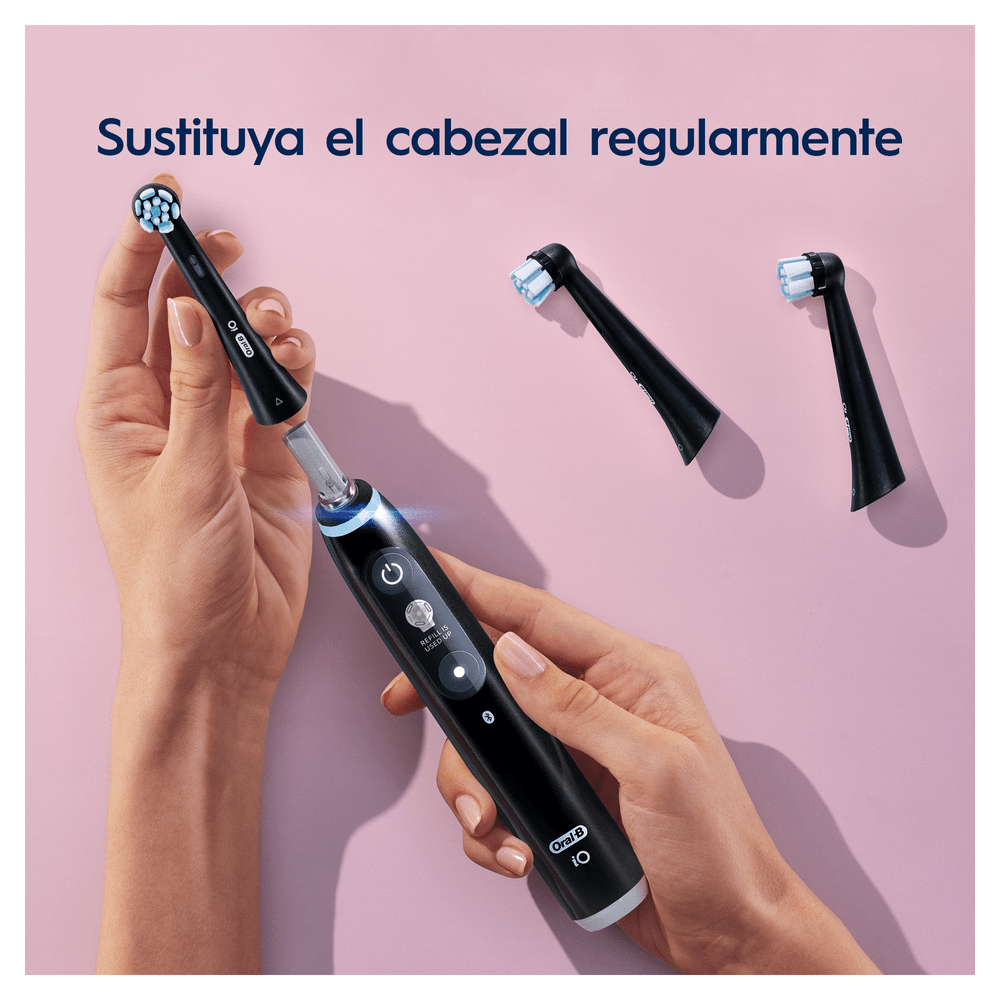 Una persona sostiene un cepillo de dientes eléctrico y cabezales de repuesto. El texto dice que se reemplacen regularmente.