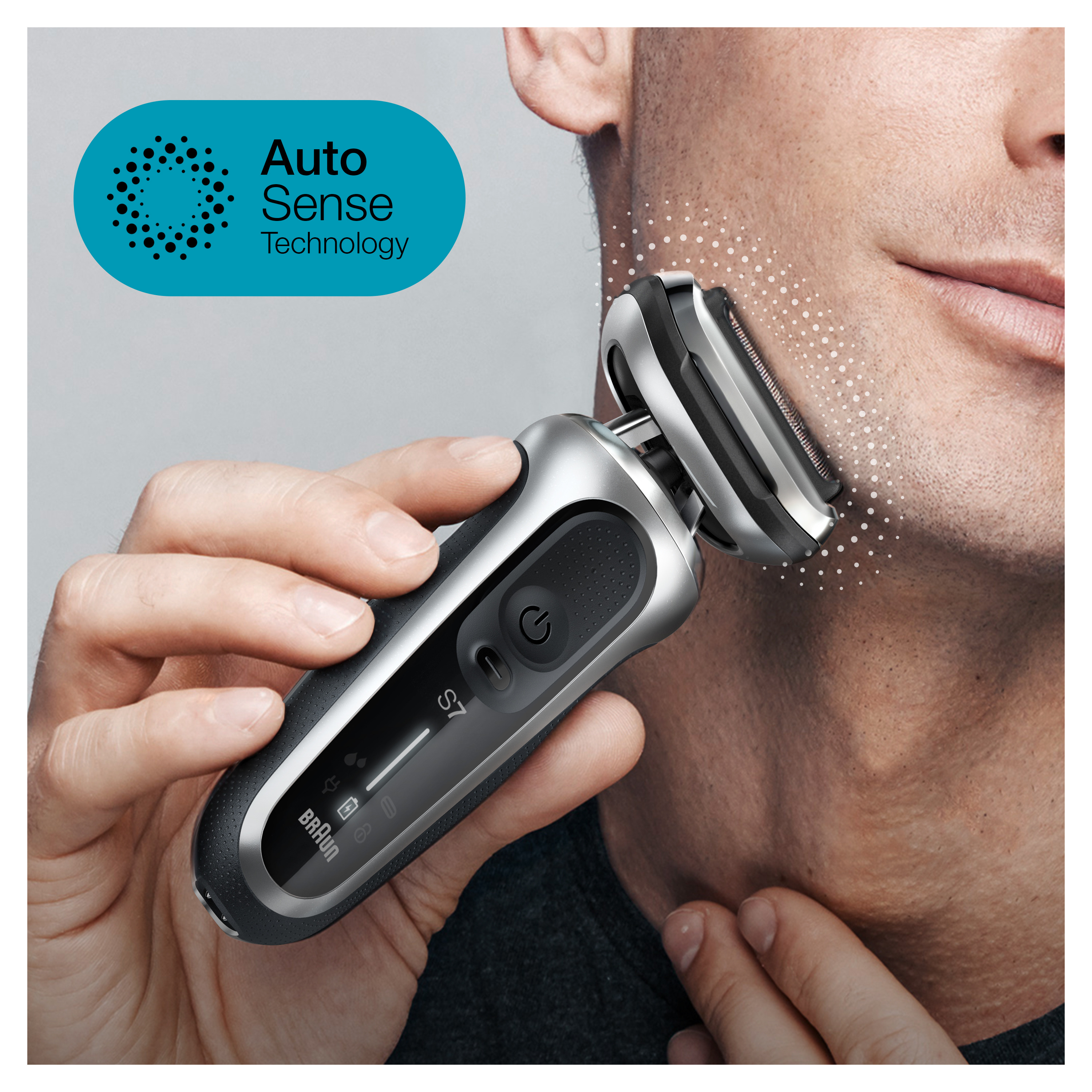 Man shaving with a silver and black electric razor, Auto Sense Technology visible.