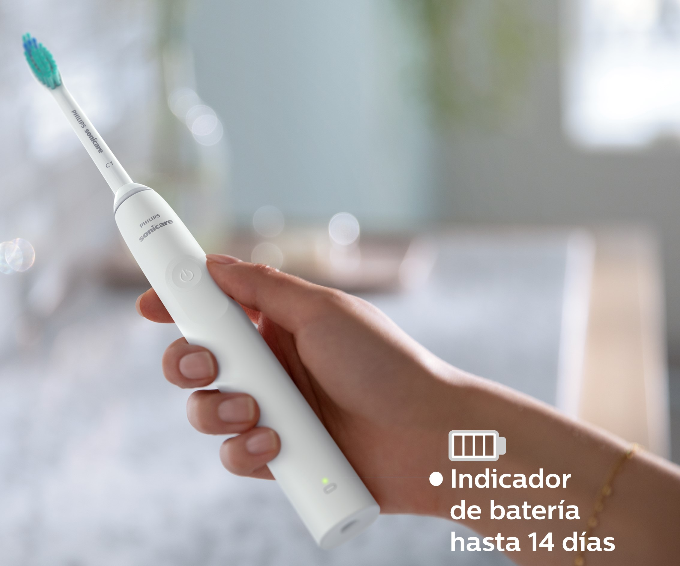 Mano sosteniendo un cepillo de dientes eléctrico blanco con indicador de batería.