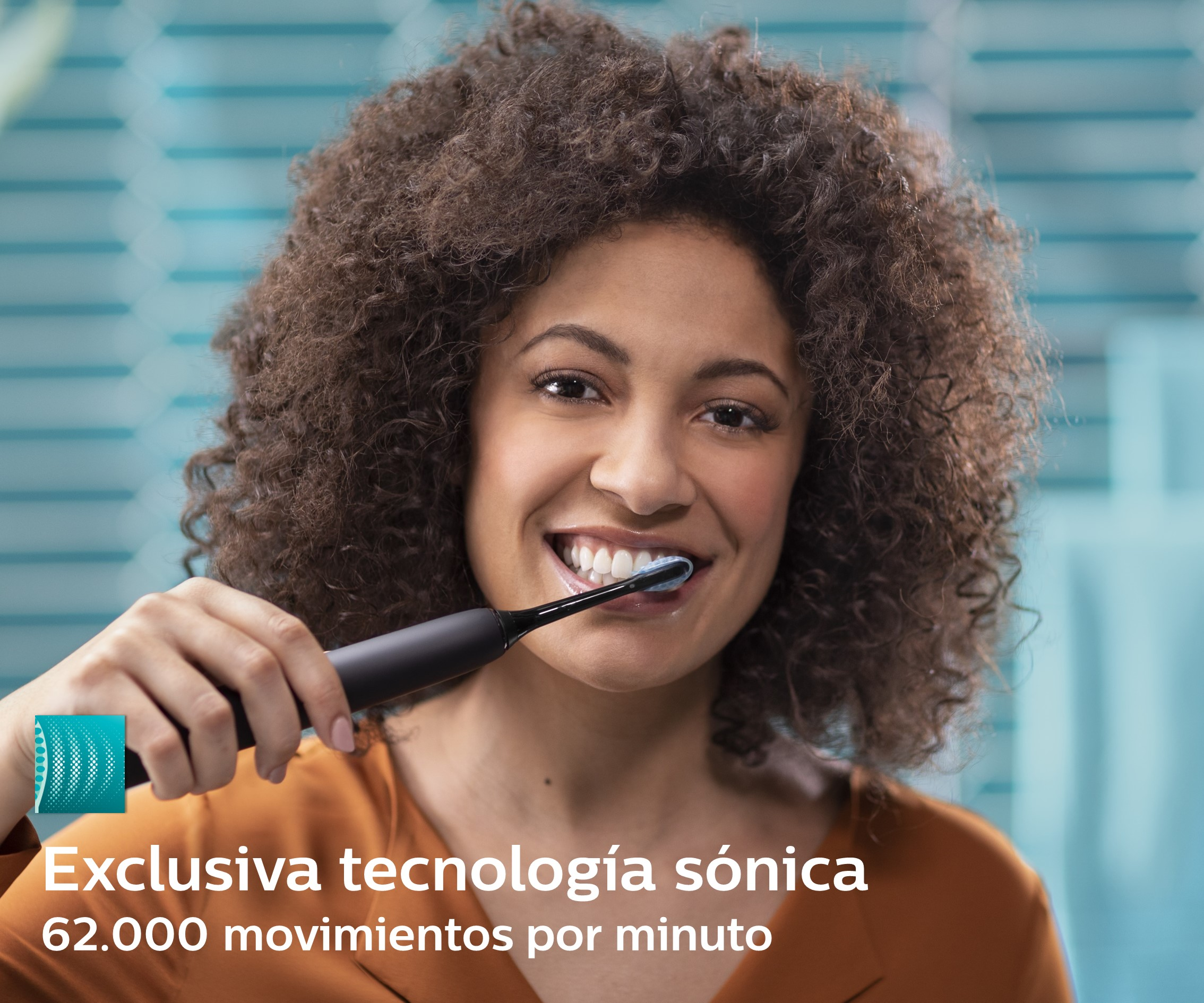 Mujer sonriendo mientras se cepilla los dientes con un cepillo eléctrico negro.