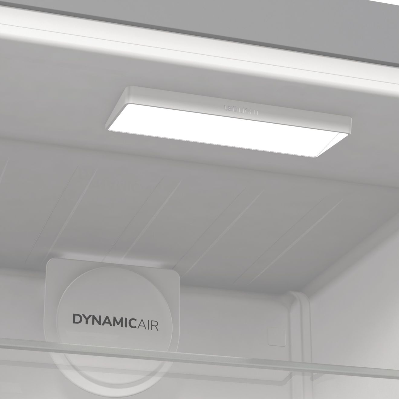Egy hűtőszekrény belseje, erős fehér fénnyel és a DynamicAir logóval. A belső tér fehér.