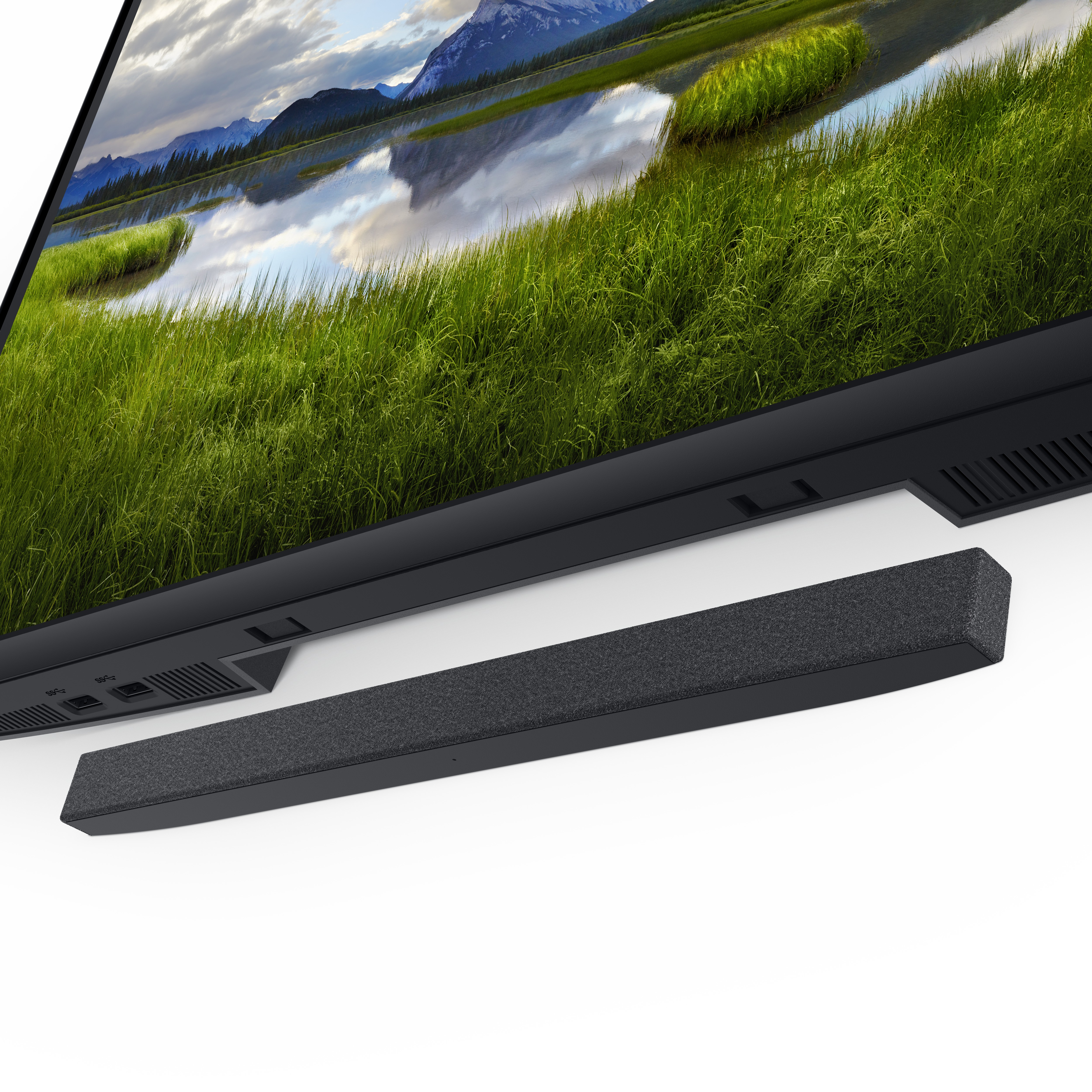 Der Monitor zeigt eine Landschaft mit Bergen, See und grünem Gras. Eine Soundbar liegt darunter.