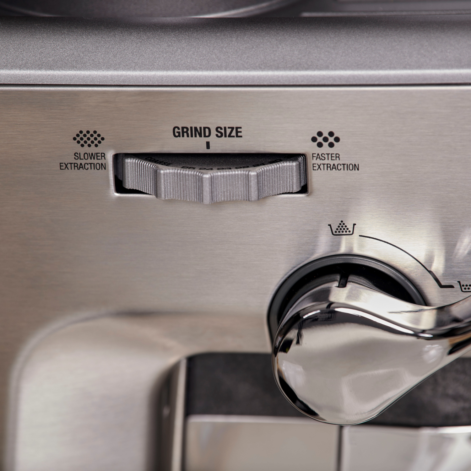 Een roestvrijstalen koffiemachine-draaiknop met maalgrootte-opties en een pijl die naar instellingen wijst.