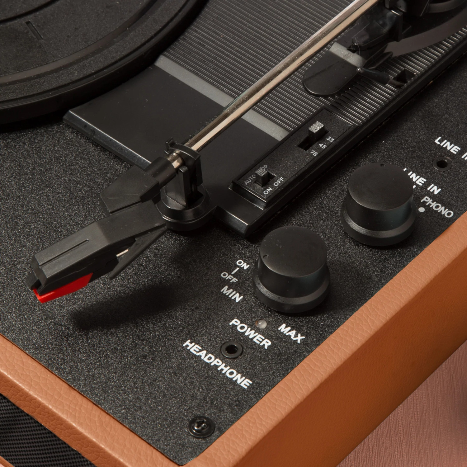 Close-up of a vintage record player's controls, including power and volume knobs.