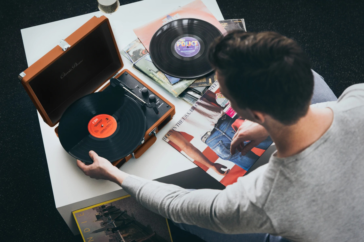 A person placing a vinyl record on a record player.