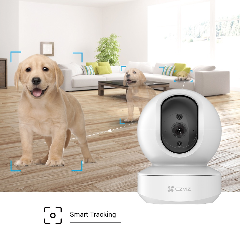 Caméra de sécurité blanche avec deux chiots à l'intérieur. Affiche une fonction de suivi intelligent.