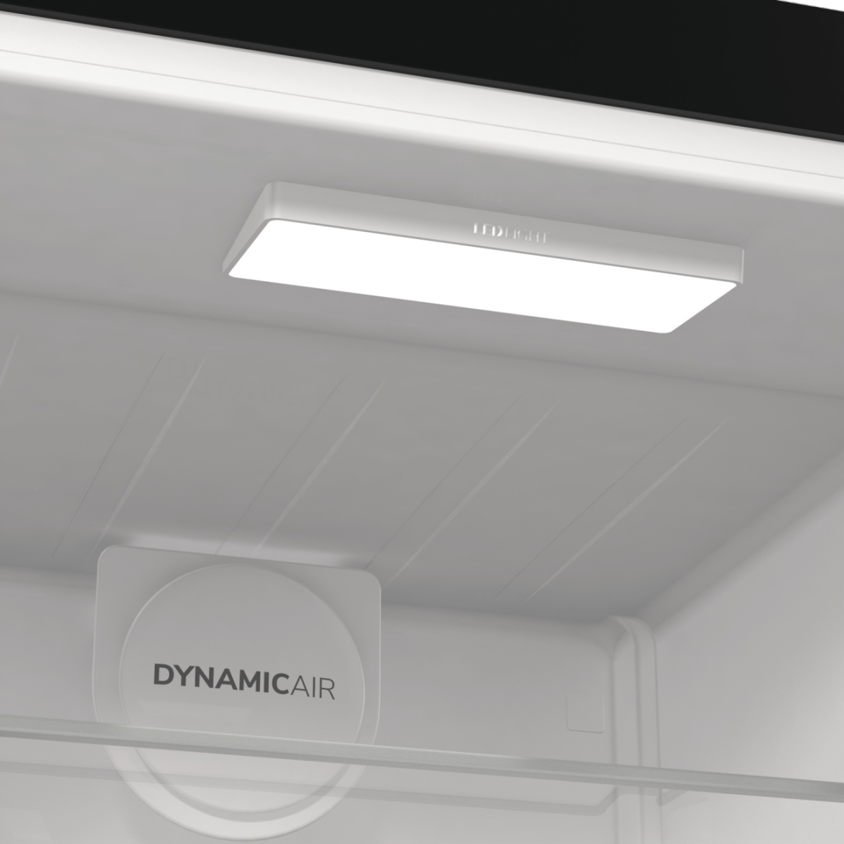 Hűtőszekrény belseje LED-es világítással és 'DYNAMIC AIR' felirattal fehér felületen.
