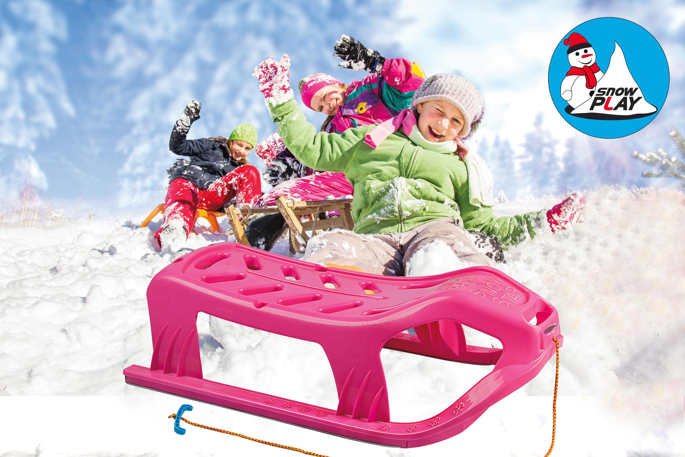 Kinder rodeln einen schneebedeckten Hügel hinunter auf einem rosa Schlitten mit Snow Play Logo.