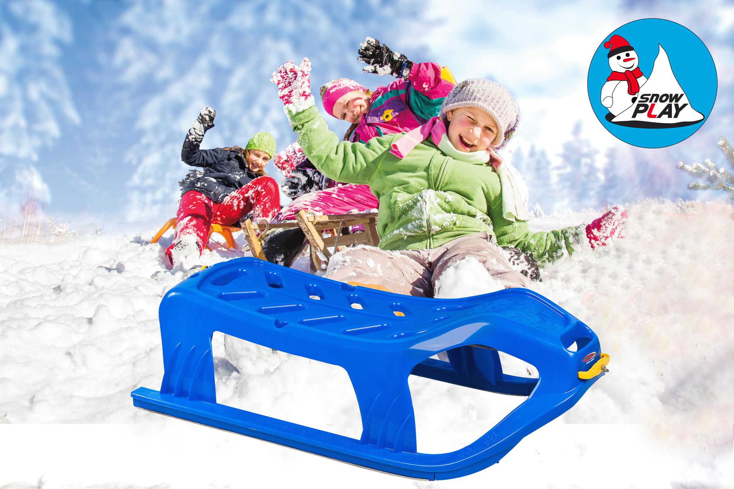 Kinder rodeln einen verschneiten Hügel hinunter mit einem blauen Schlitten, im Hintergrund Schnee.