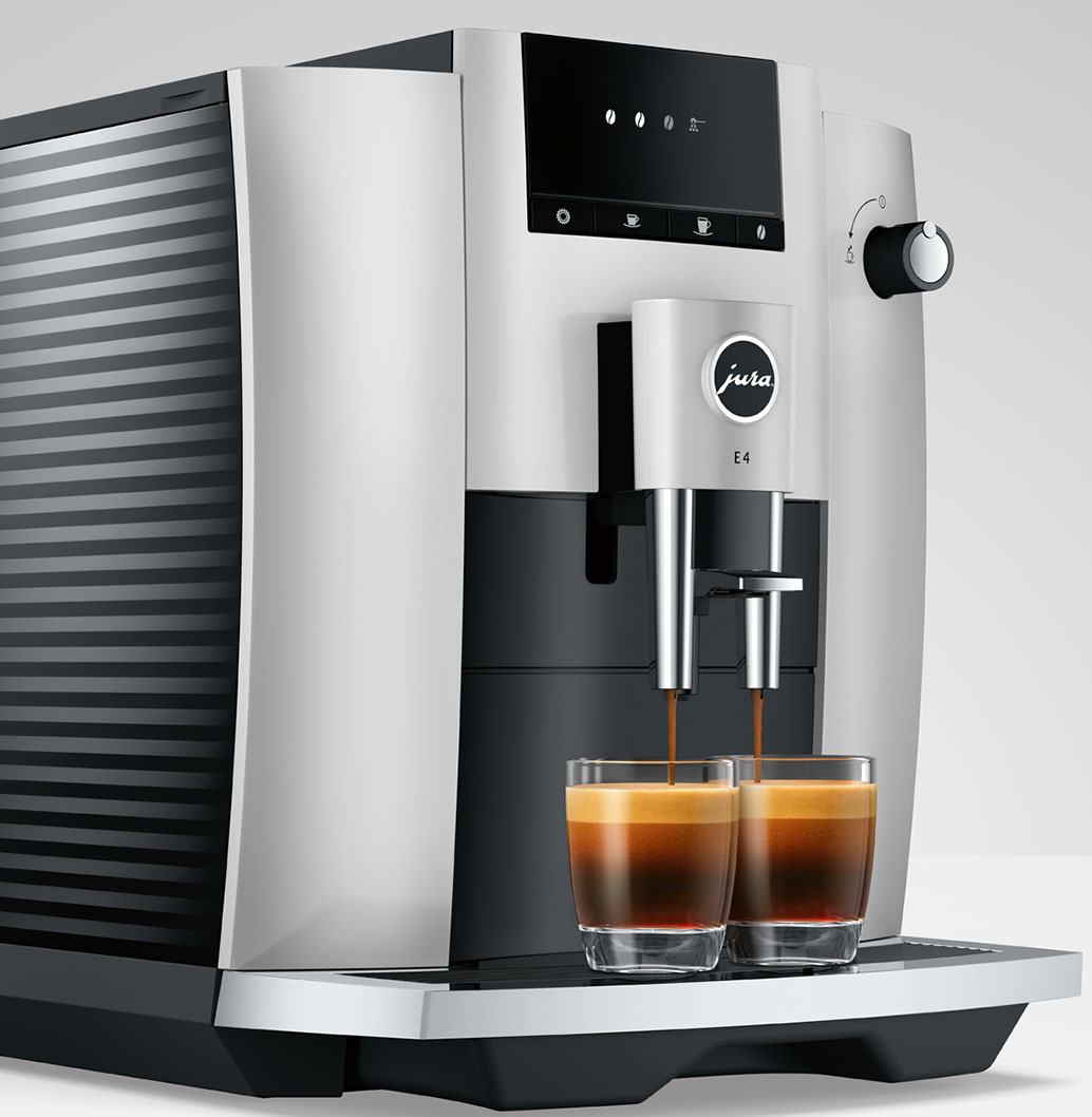 Una macchina da caffè Jura E4 argento e nera, che eroga caffè in due bicchieri.
