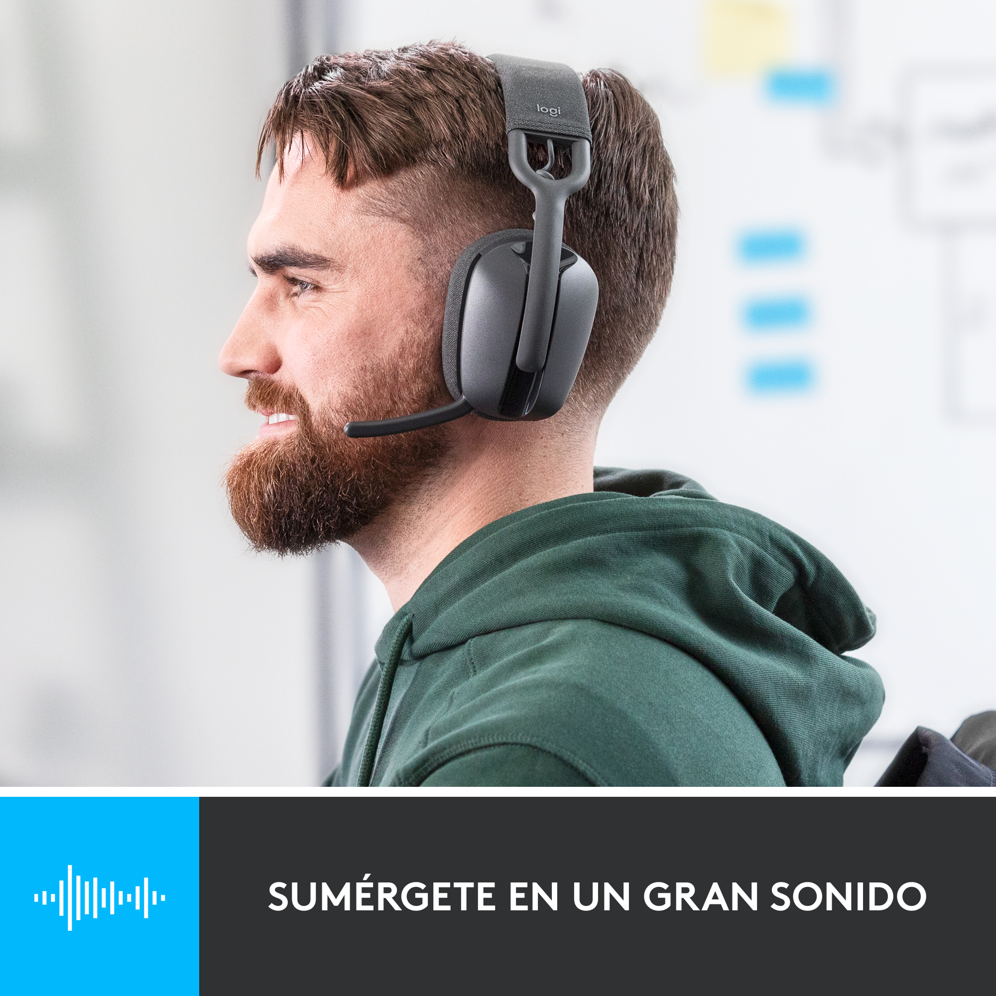 Hombre con auriculares, suéter verde, pared blanca, texto: 'Sumérgete en un gran sonido'.