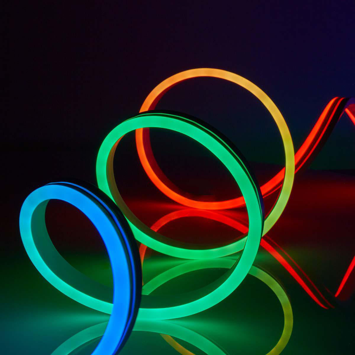 Neonlichter in Blau, Grün, Orange und Rot, bilden kreisförmige Formen und Reflexionen.