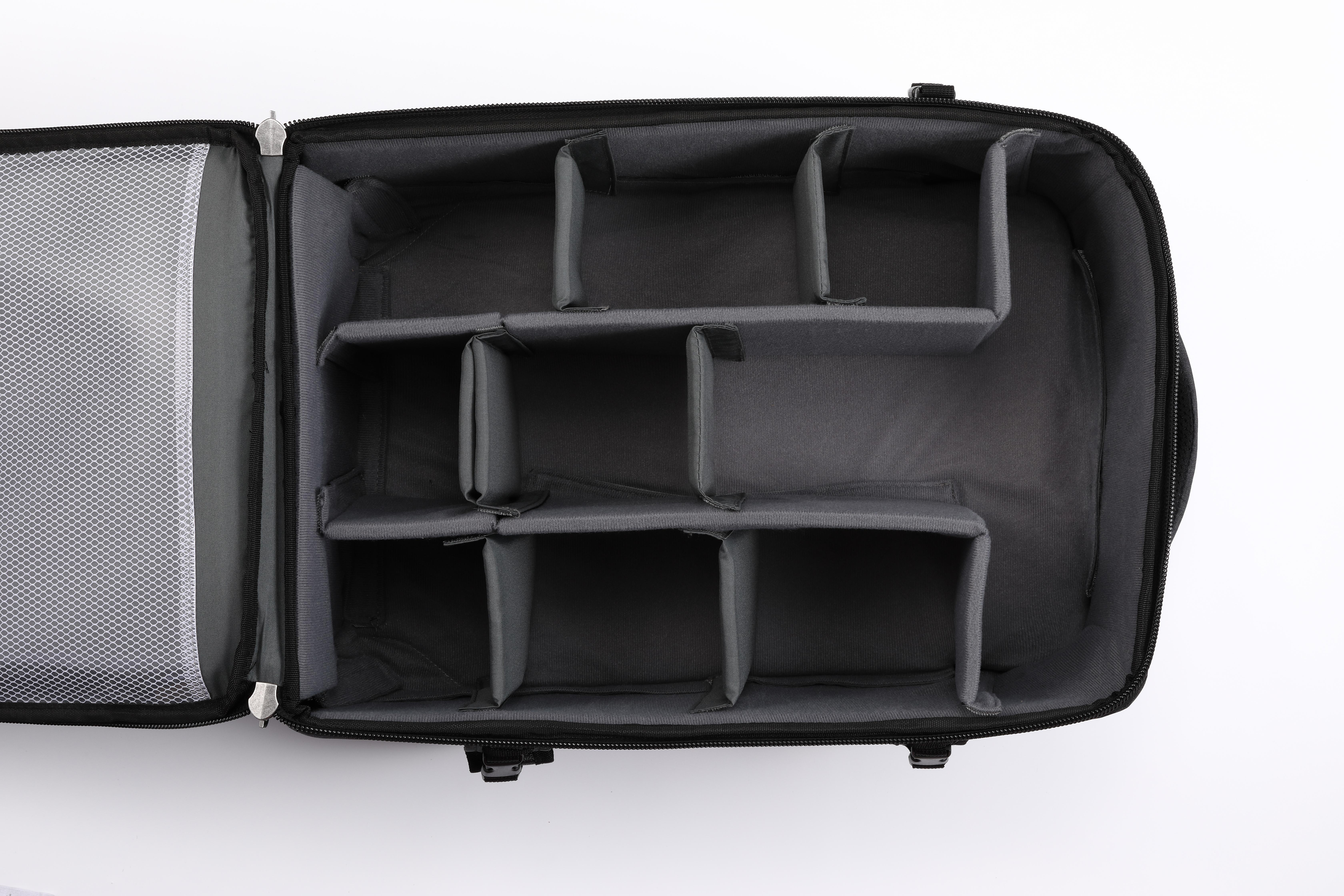 Innenseite einer schwarzen Tasche mit grauen Trennwänden, die Fächer bilden, auf weißer Oberfläche.