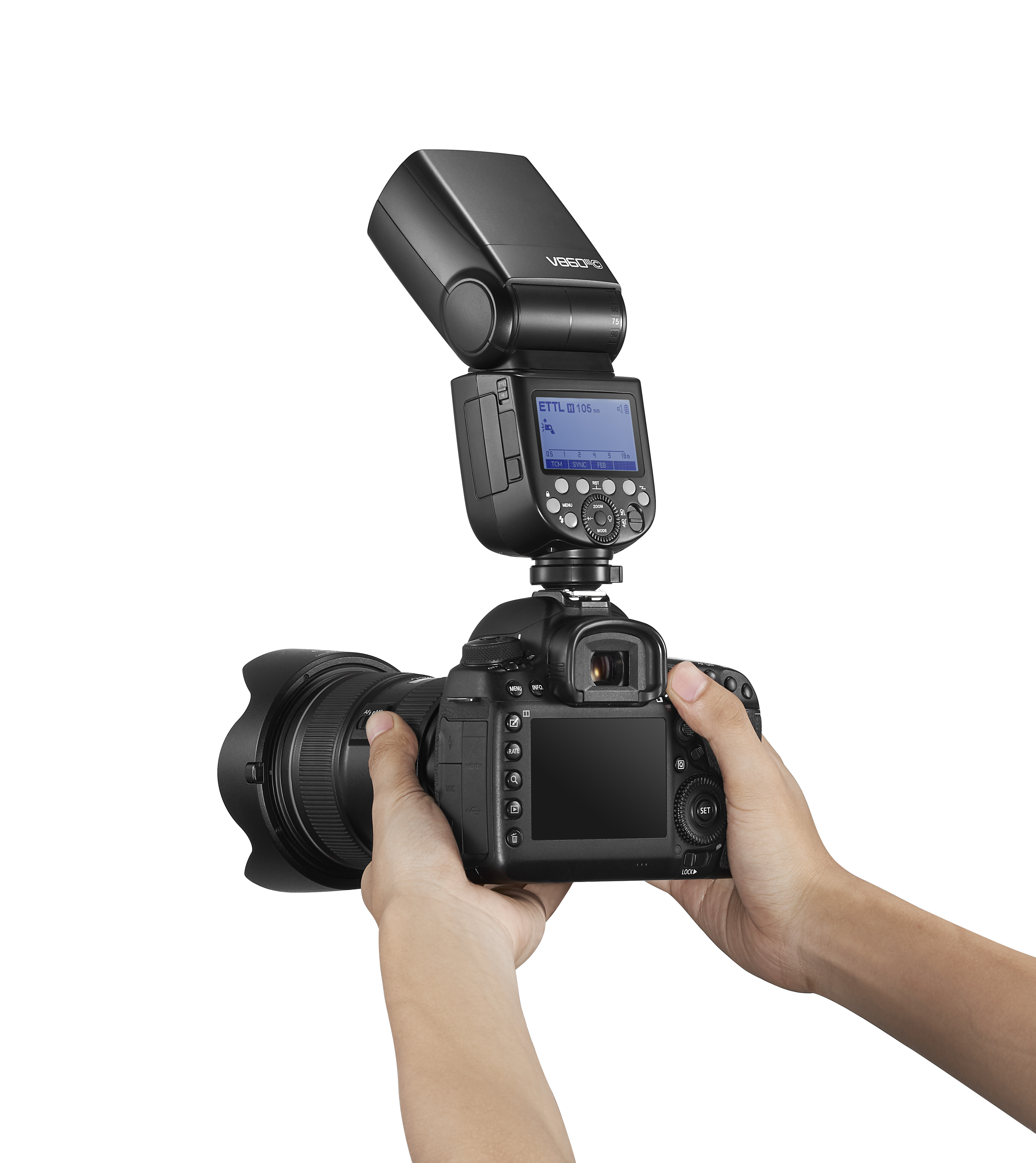 Eine DSLR-Kamera mit Blitz, gehalten von zwei Händen vor weißem Hintergrund.