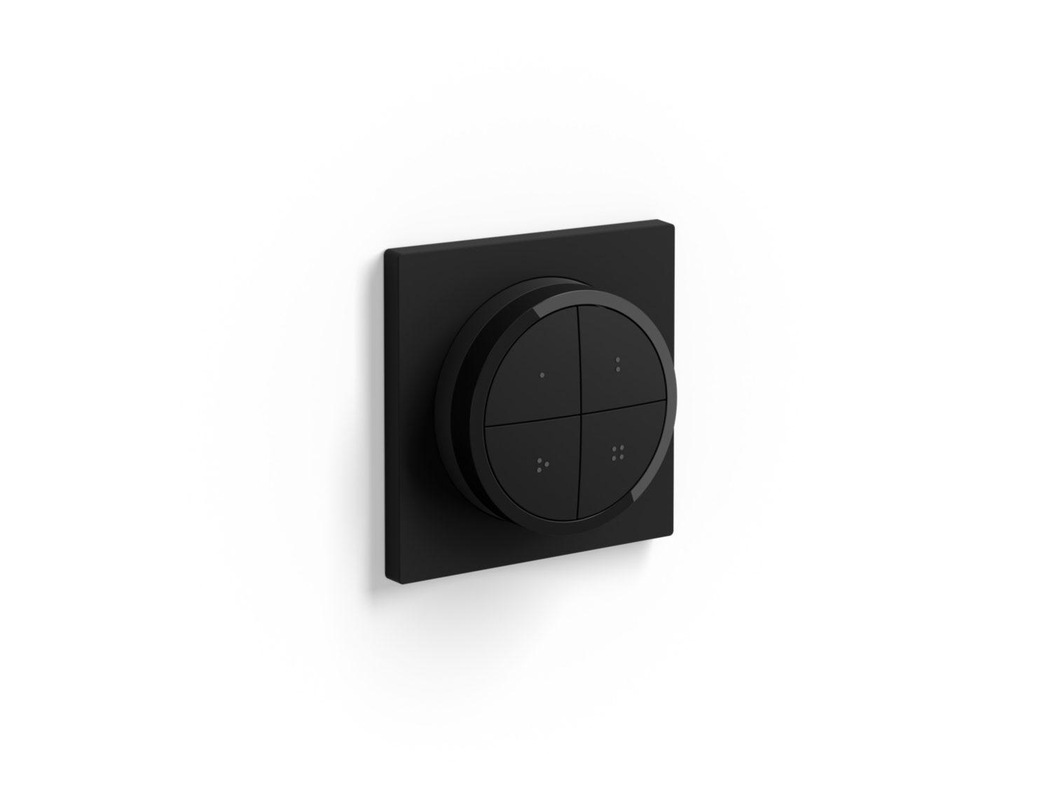 Schwarzes Bedienfeld mit Drehknopf und vier knopfartigen Abschnitten an weißer Wand.