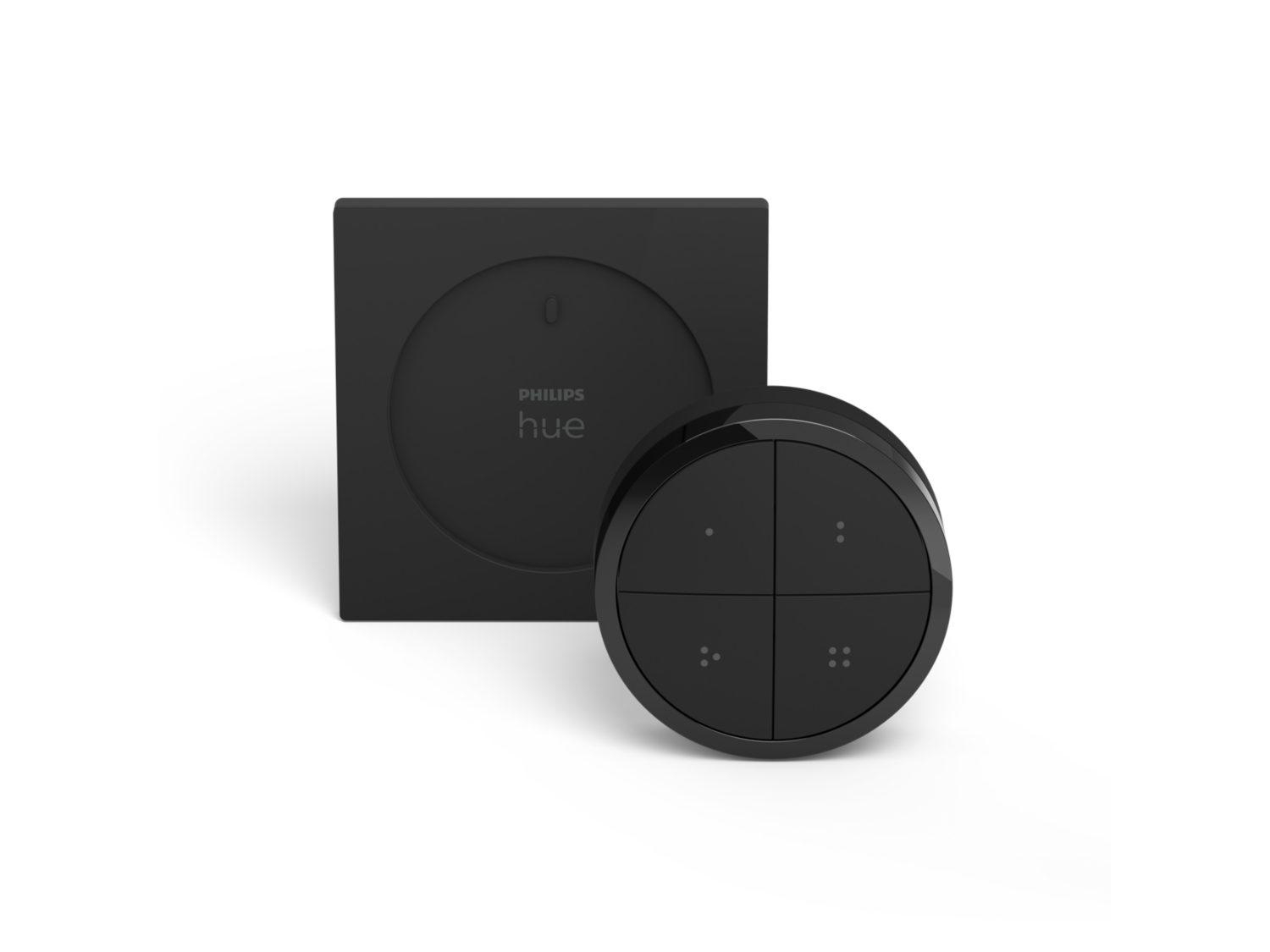Schwarzer Philips Hue Smart Button und quadratisches Bedienfeld auf weißem Hintergrund. Der Knopf hat vier Tasten.