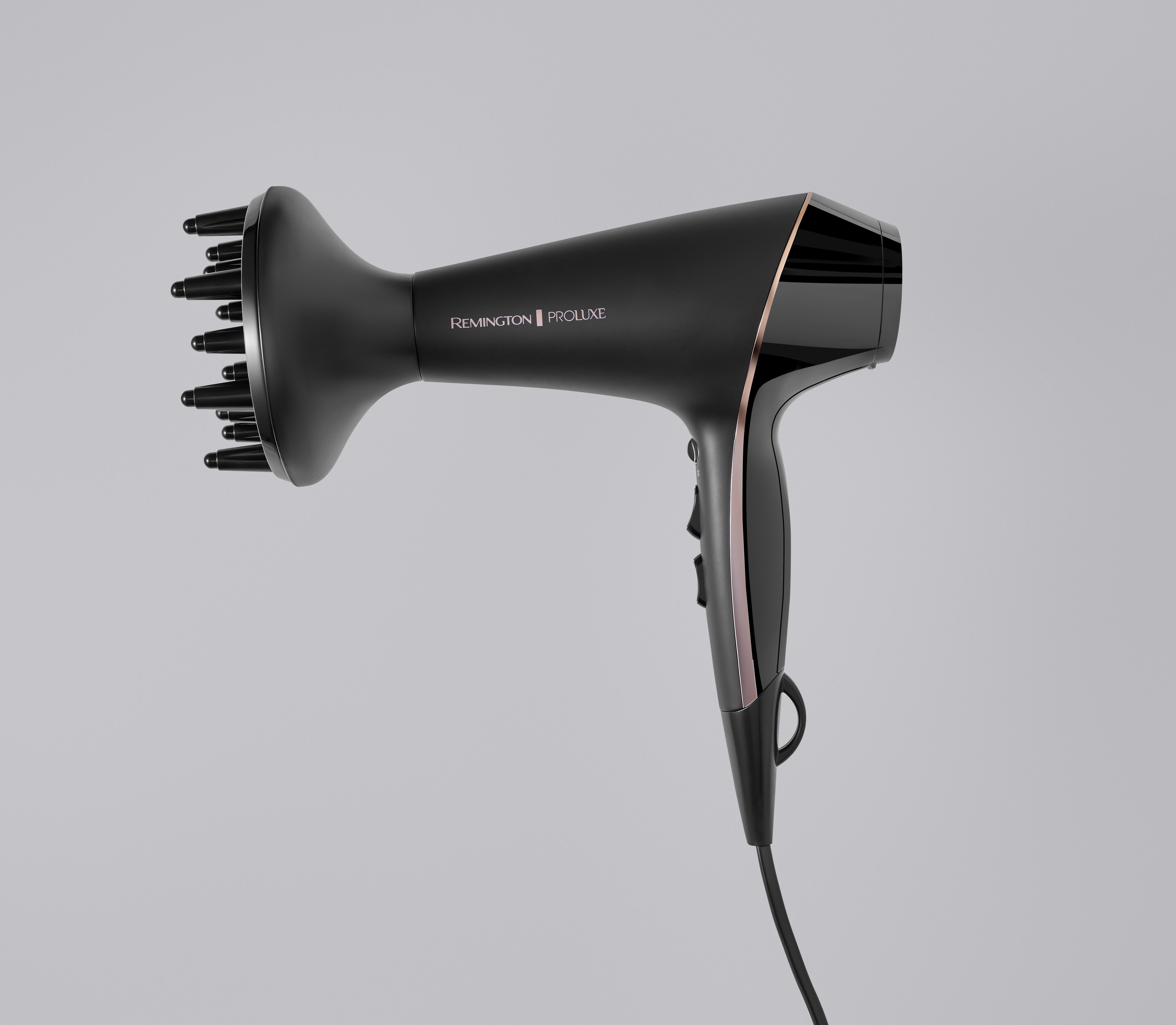 Ein schwarzer Haartrockner, Remington Proluxe, mit Diffusoraufsatz, auf grauem Hintergrund.