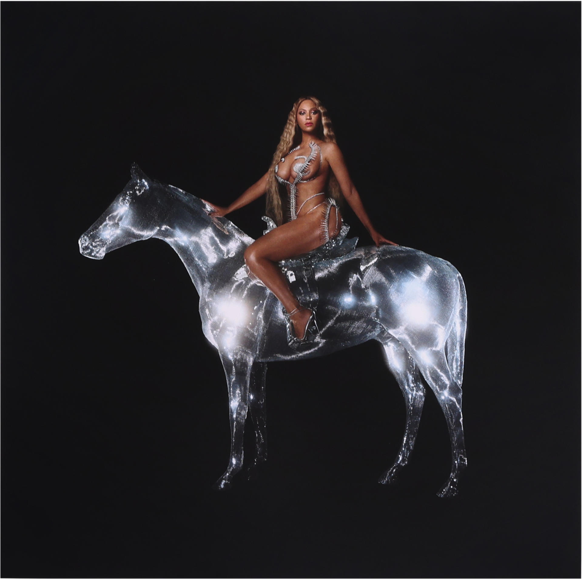 Beyoncé auf einem silbernen Pferd. Sie trägt ein silbernes Outfit auf schwarzem Hintergrund.