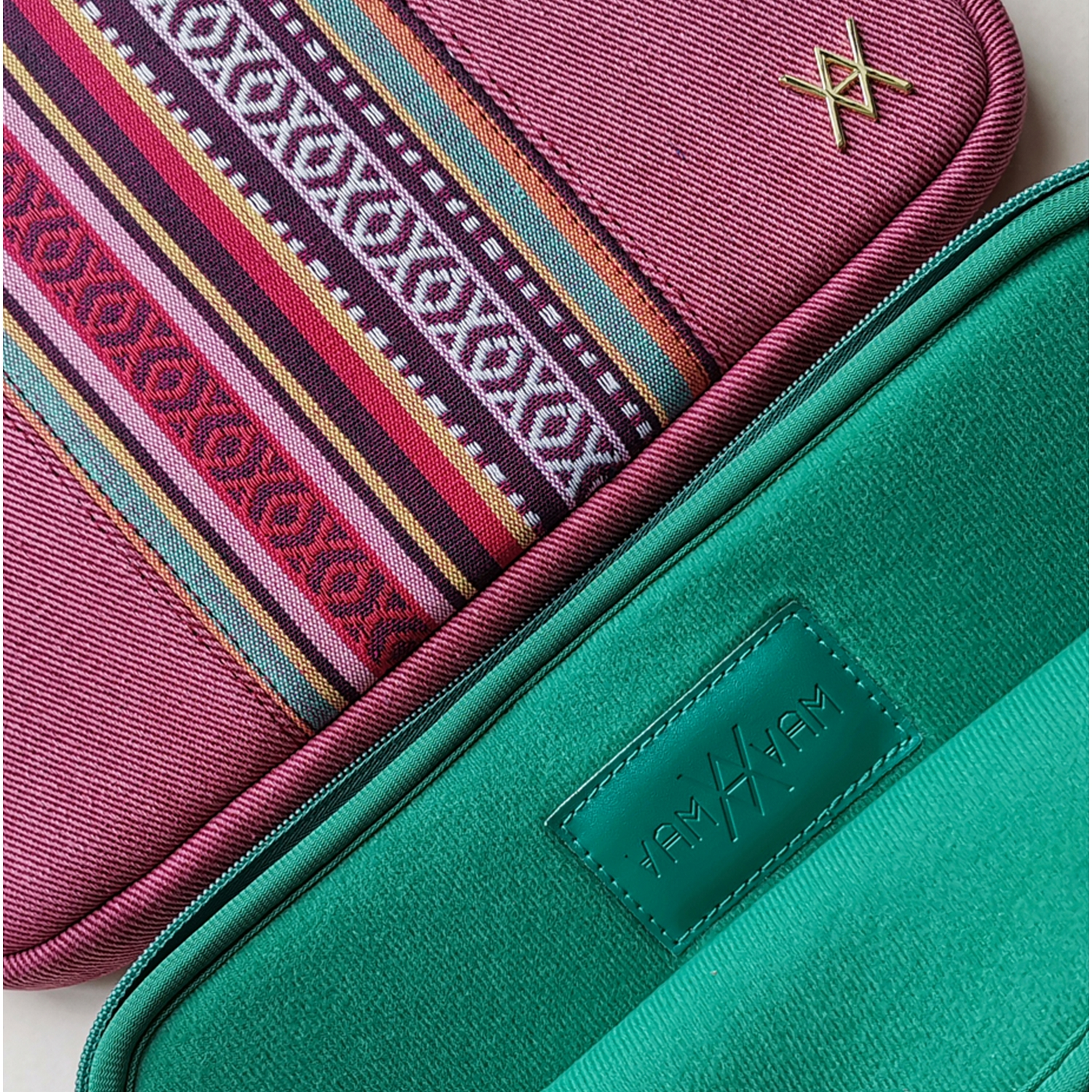 Primer plano de dos fundas para portátiles, una estampada, otra verde con logotipo.