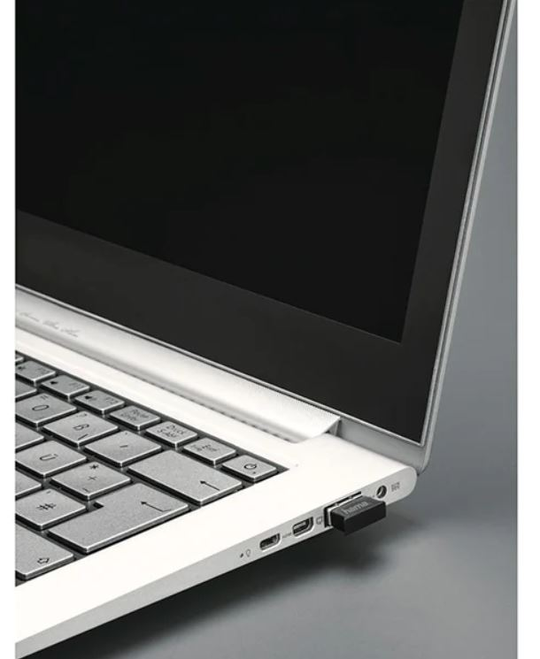 Siyah USB dongle takılı beyaz bir dizüstü bilgisayar.