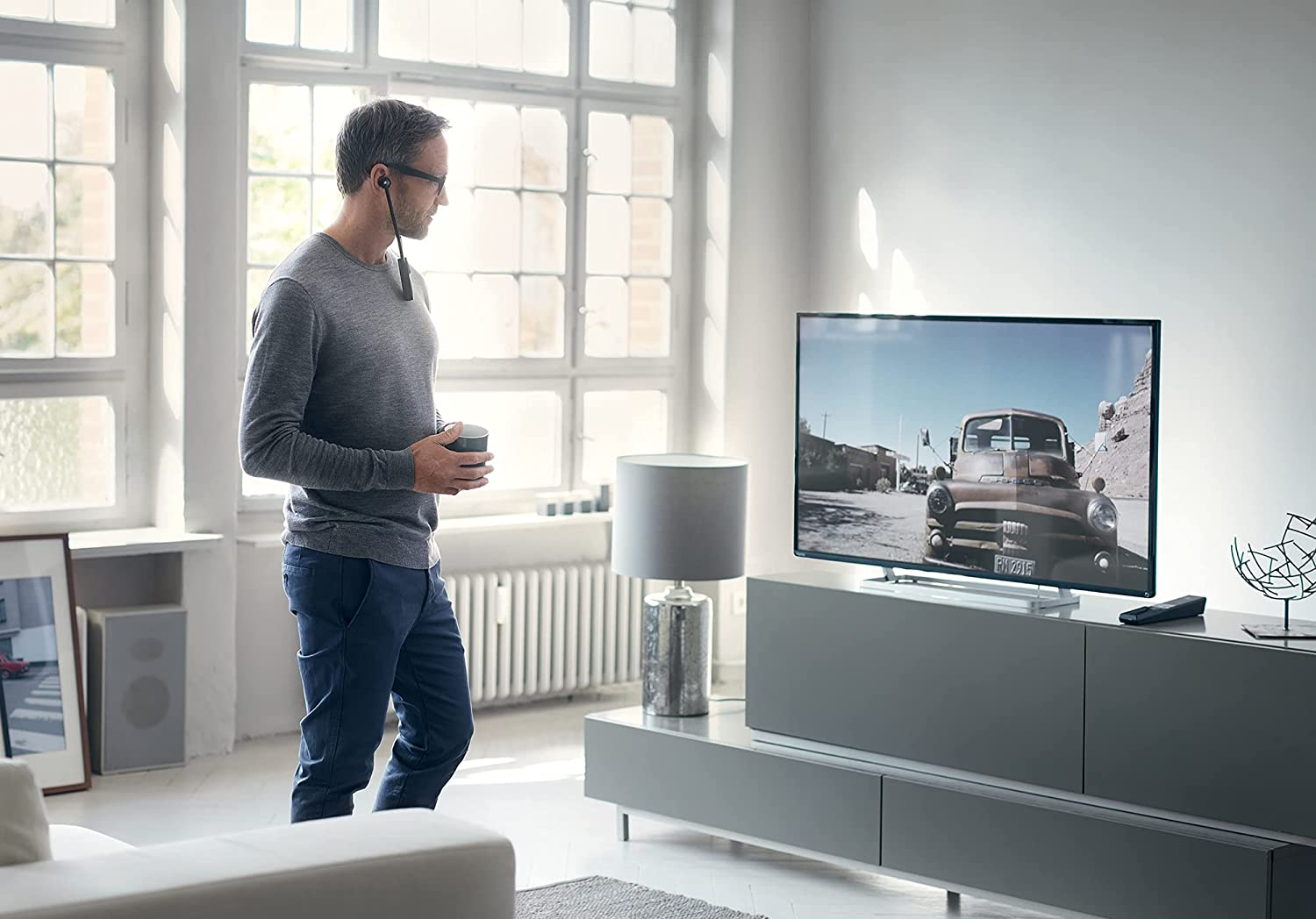Férfi csészével, TV-t néz autóval.
