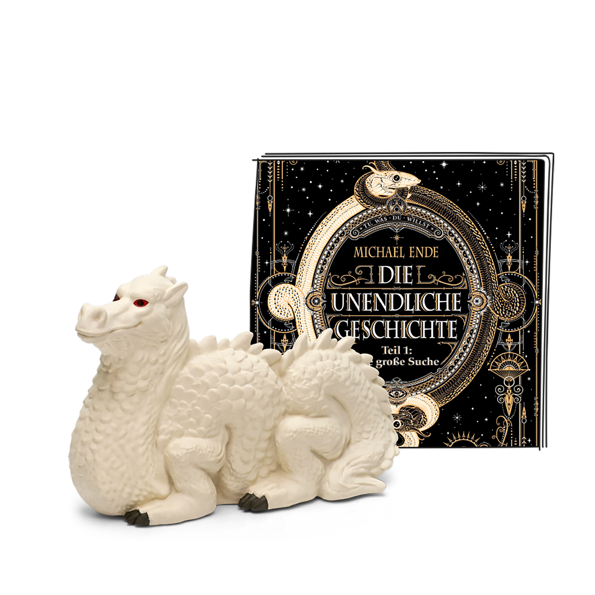 Ein weißes Drachenspielzeug und ein Buch mit dem Titel Die unendliche Geschichte von Michael Ende auf weißem Untergrund.