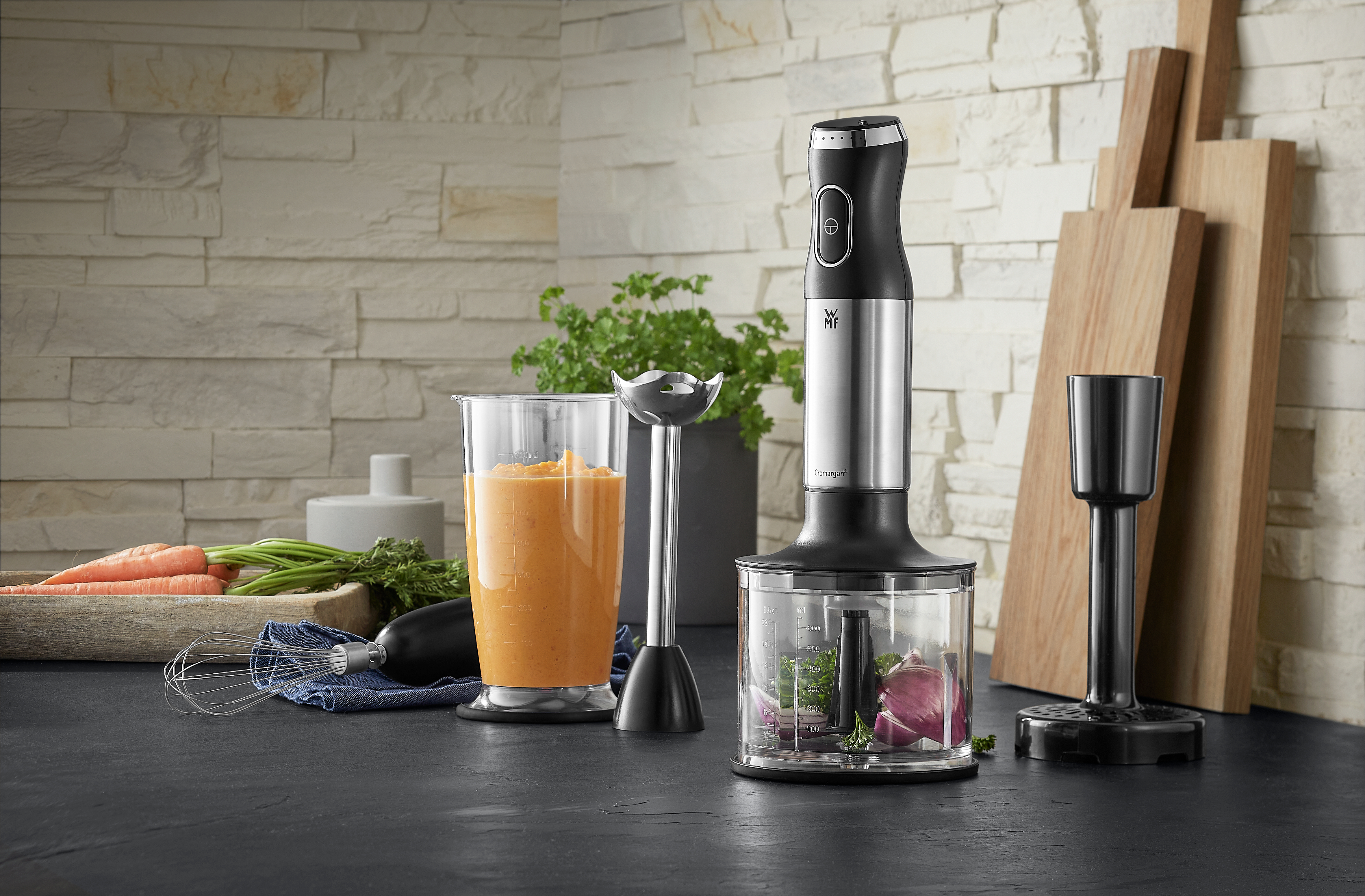 Verschiedene Küchenutensilien: ein Mixer, ein Glas mit Smoothie und Schneidebretter.