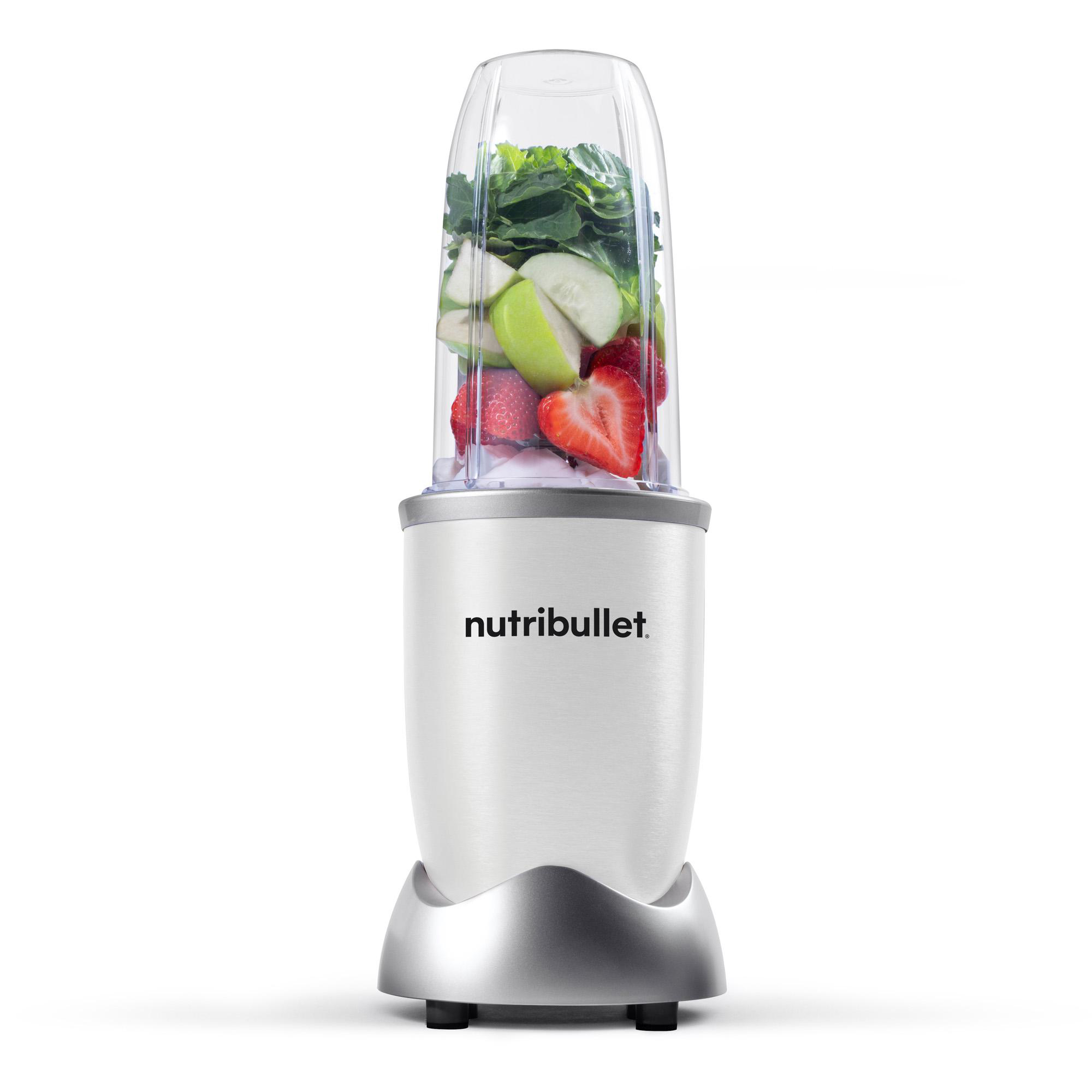 Ein silberner Nutribullet Mixer mit Früchten und Grünzeug im transparenten Behälter.