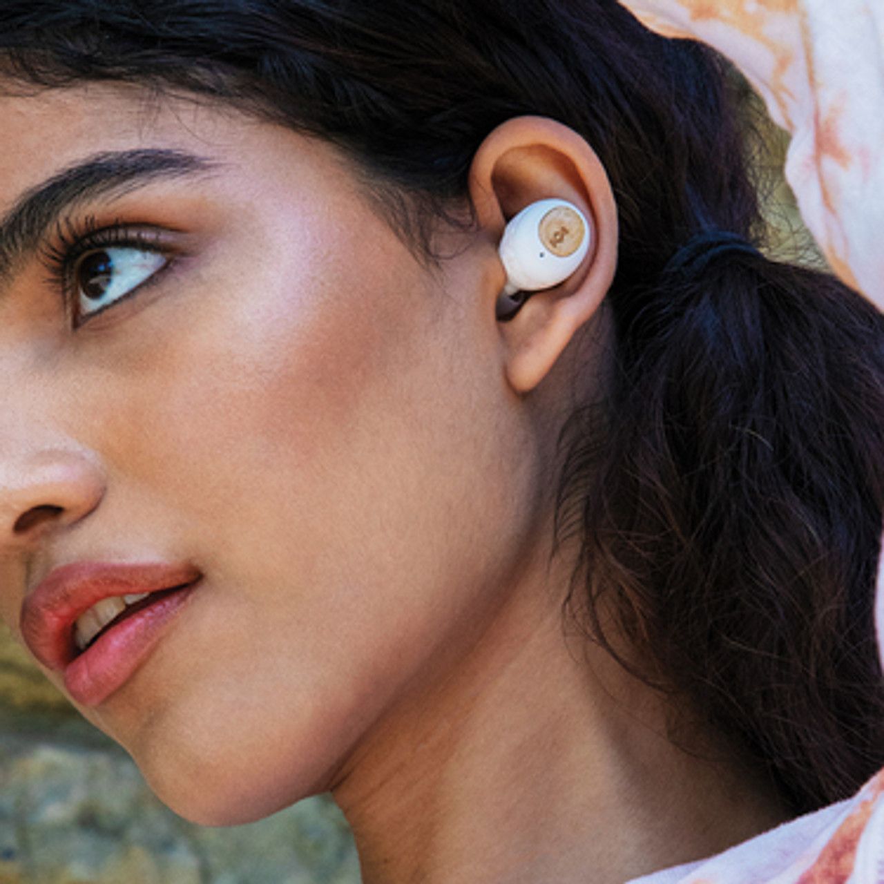 Donna che usa un auricolare. L'auricolare è bianco.