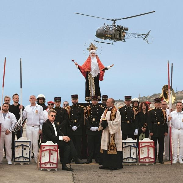 Groep mensen, priester en helikopter. Een religieuze scène met een helikopter en mensen.